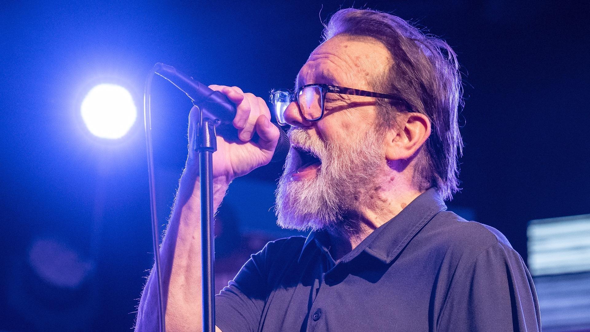 Mike Connell of The Connells singing into a microphone.