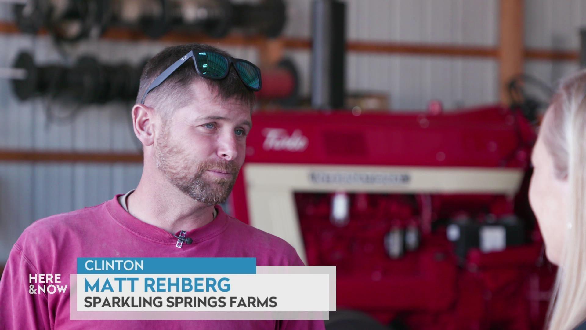 A still image shows Matt Rehberg standing in front of a large red tractor, with a graphic at the the bottom that reads 'Clinton,' 'Matt Rehberg,' and 'Sparkling Springs Farms.'
