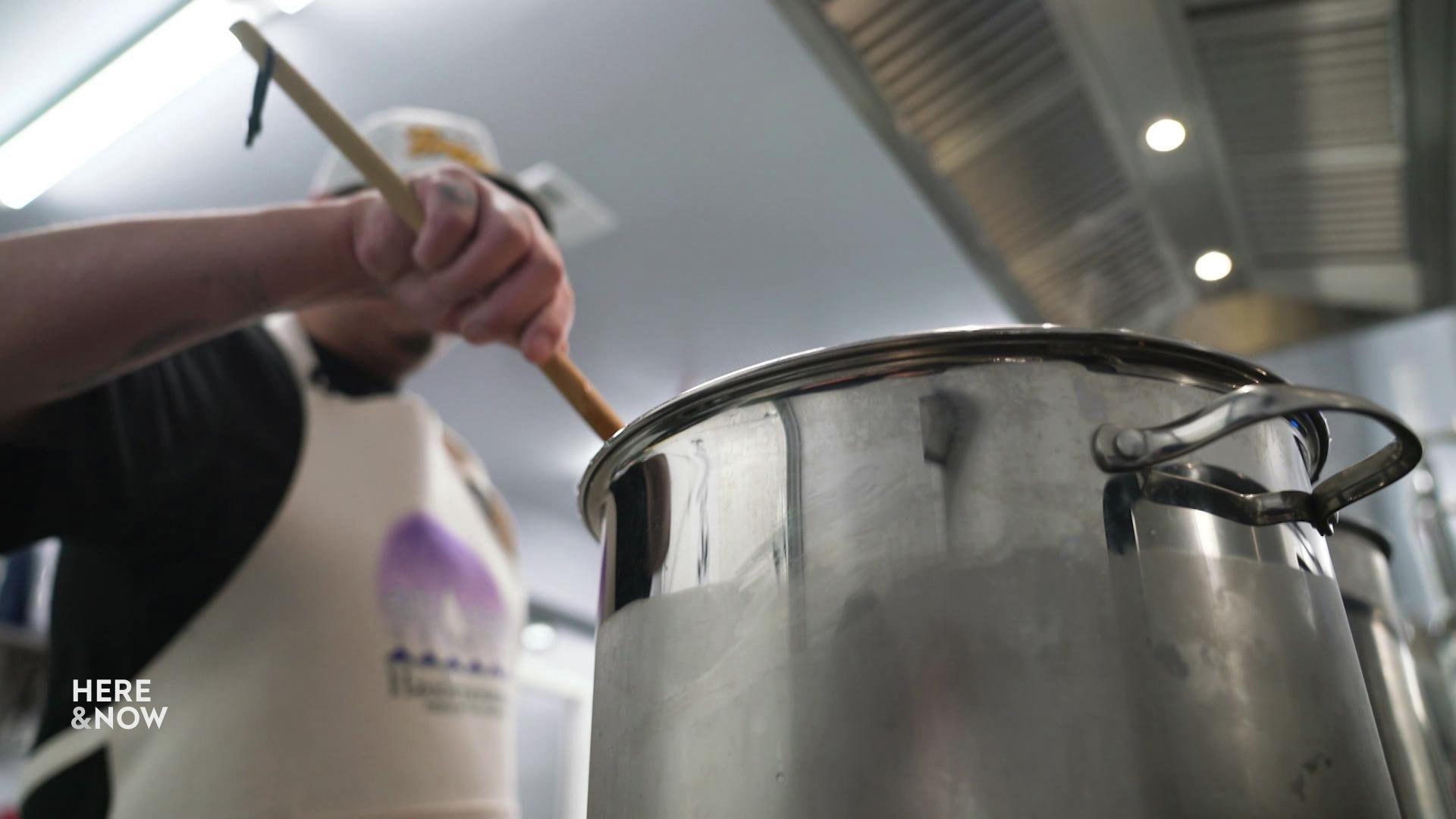 A still image shows a chef stirring a large pot.