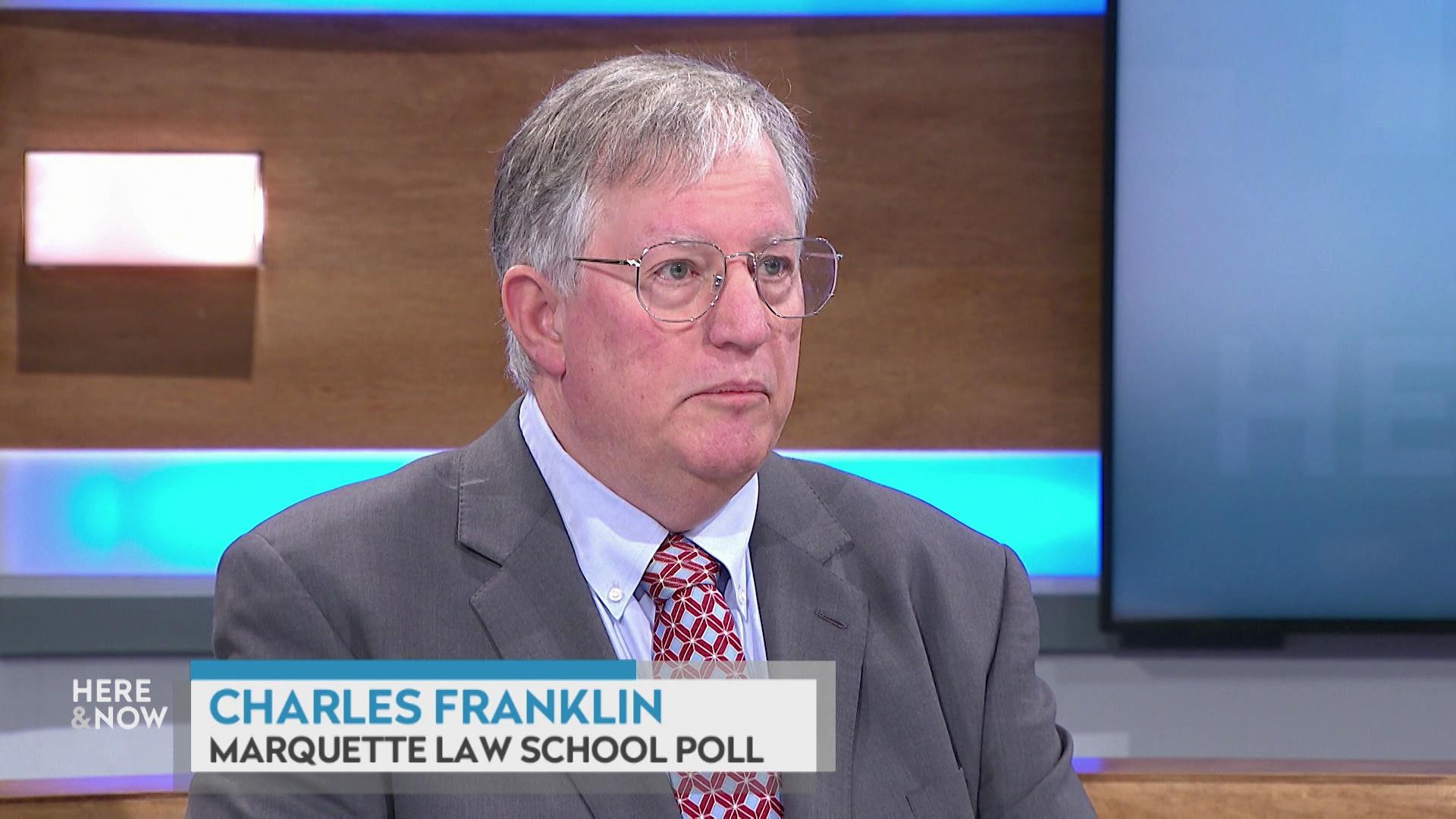 A still image shows Charles Franklin seated at the 'Here & Now' set featuring wood paneling, with a graphic at bottom reading 'Charles Franklin' and 'Marquette Law School Poll.'