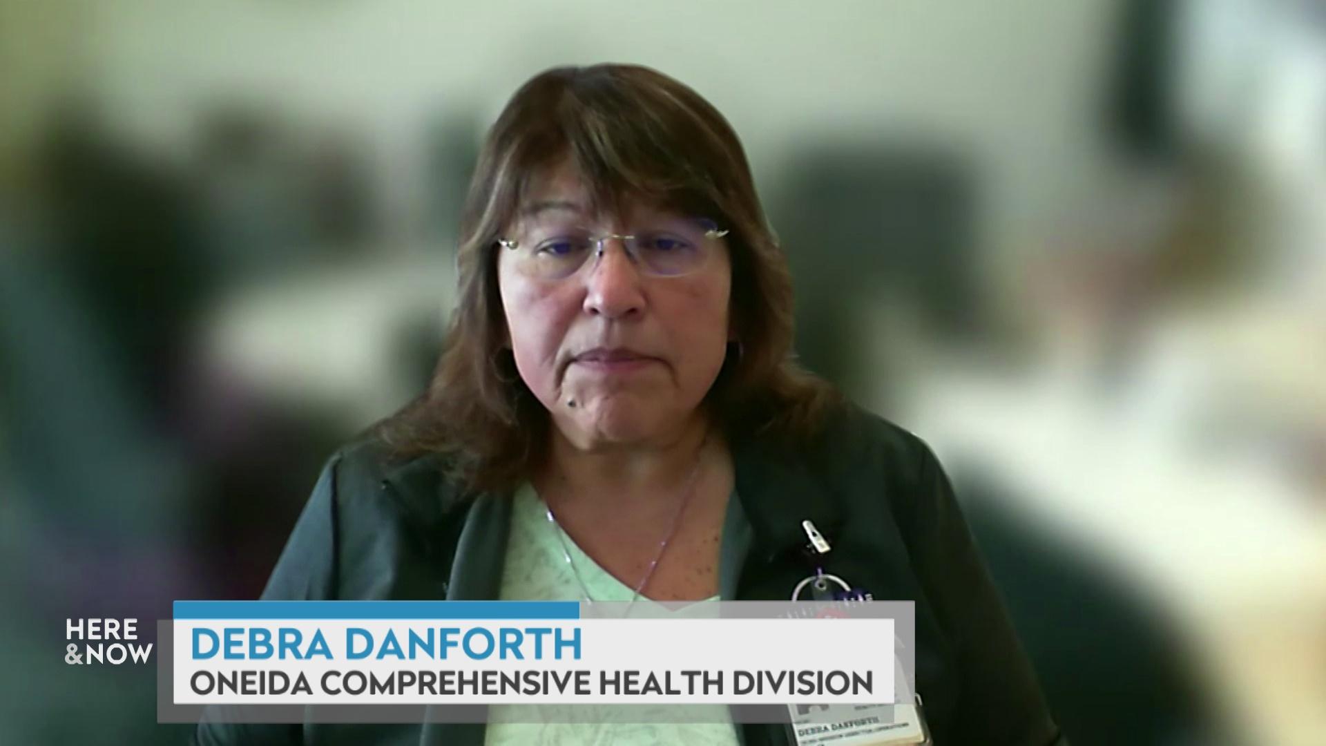 A still image from a video shows Debra Danforth sitting in front of a blurred background with a graphic at bottom reading 'Debra Danforth' and 'Oneida Comprehensive Health Division.'