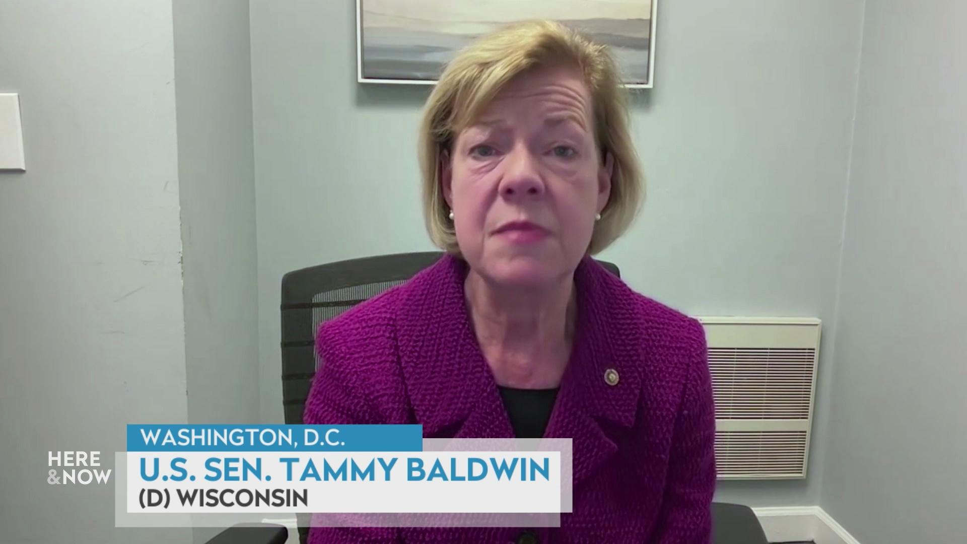 A still image from a video shows Tammy Baldwin seated in front of framed artwork on the wall with a graphic at bottom reading 'Washington, D.C.,' 'U.S. Sen. Tammy Baldwin' and '(D) Wisconsin.'