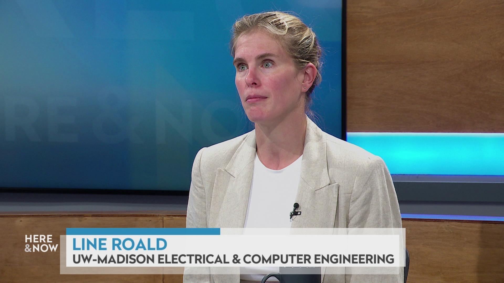 A still image shows Line Roald seated at the 'Here & Now' set featuring wood paneling, with a graphic at bottom reading 'Line Roald' and 'UW-Madison Electrical & Computer Engineering.'