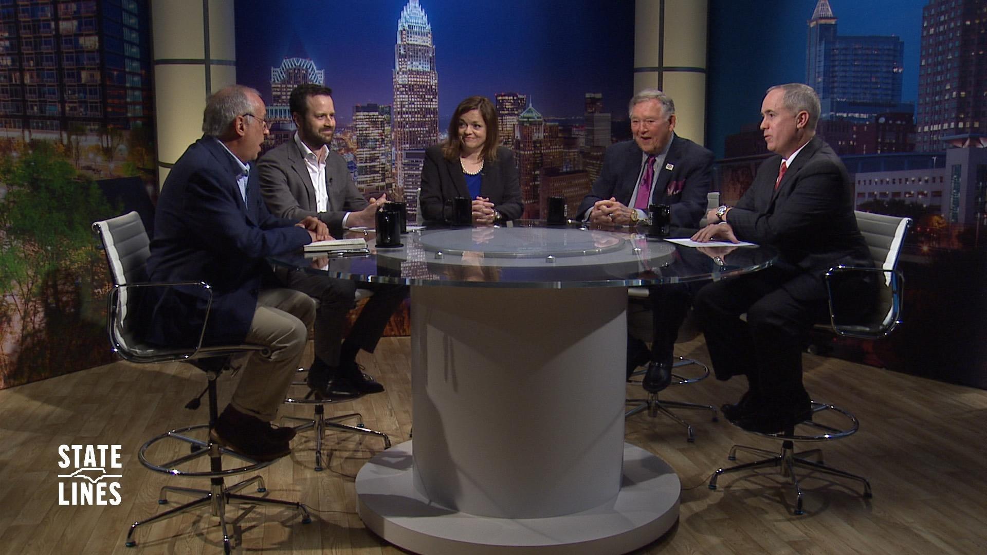 State Lines host Kelly McCullen and panelists sit at a round table on the set of State Lines.