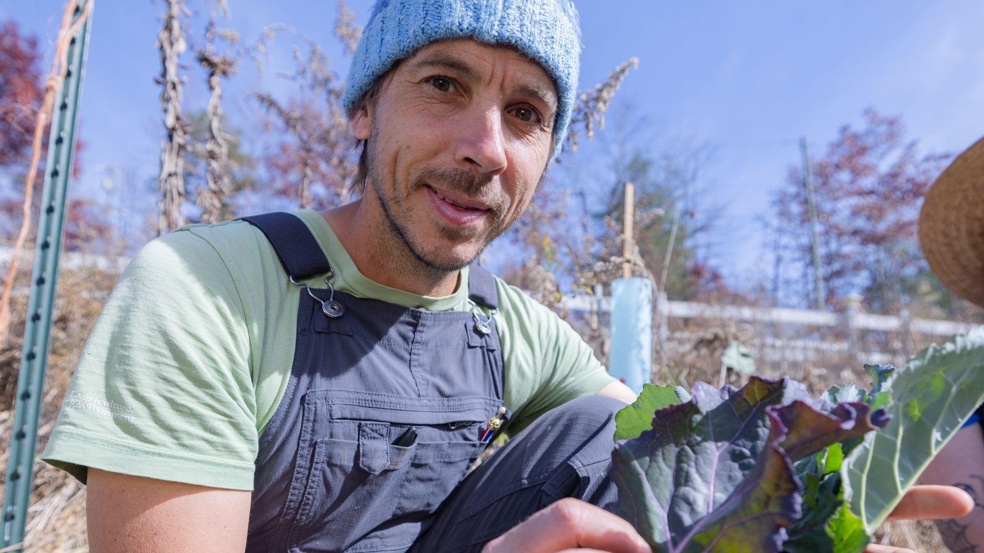 Chris Smith smiles while holding some collard greens, as featured in State of Change: Seeds of Hope.
