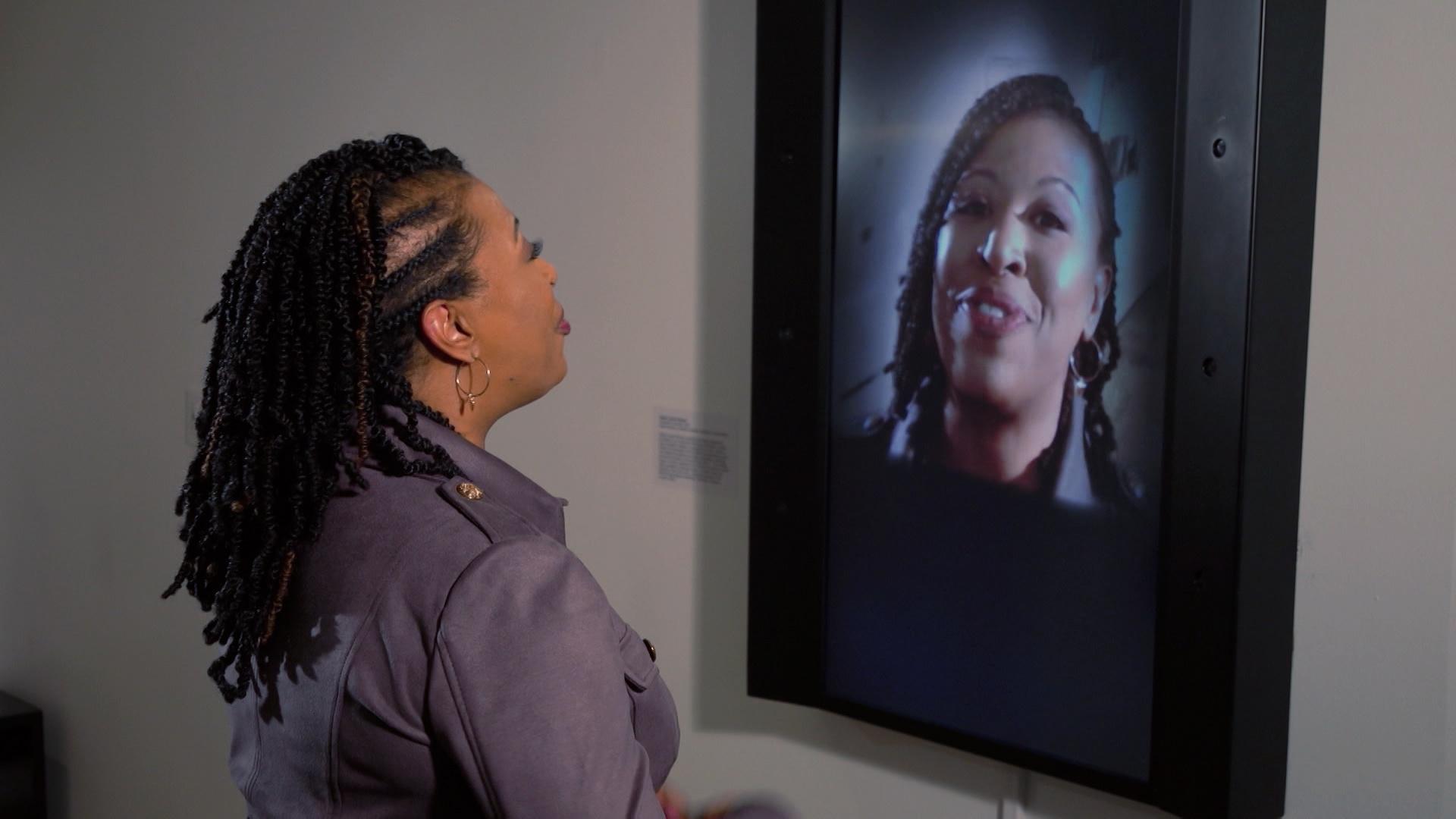 Host of NC Weekend, Deborah Holt Noel, looks at herself in a screen that's showing her through a camera.