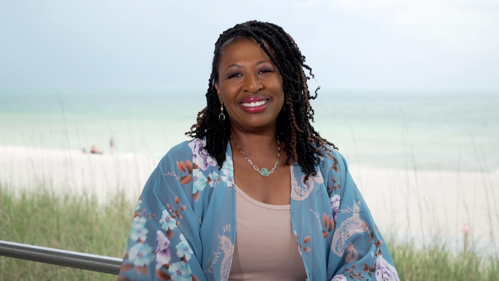 Deborah Holt Noel, host of NC Weekend in front of a beach on Ocracoke.