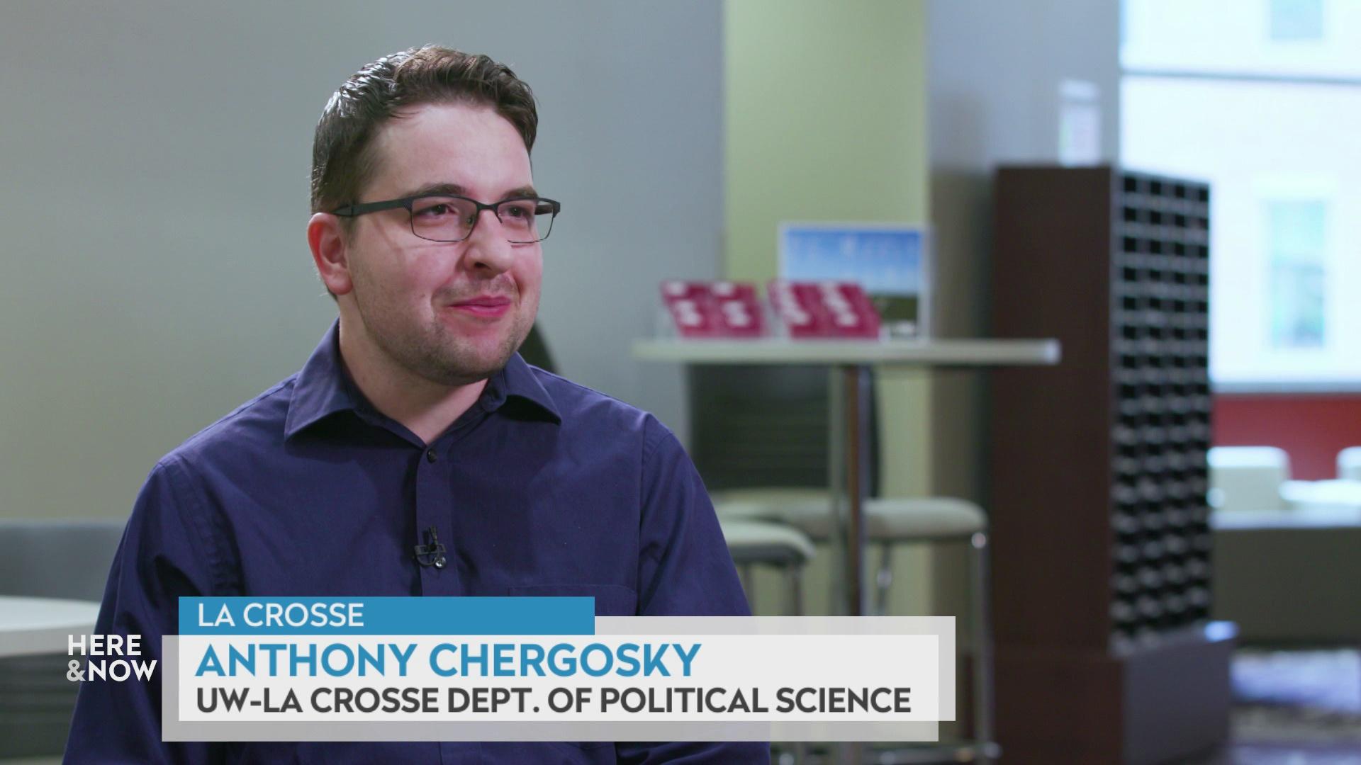 Anthony Chergosky sits indoors with a table and chairs in the background.