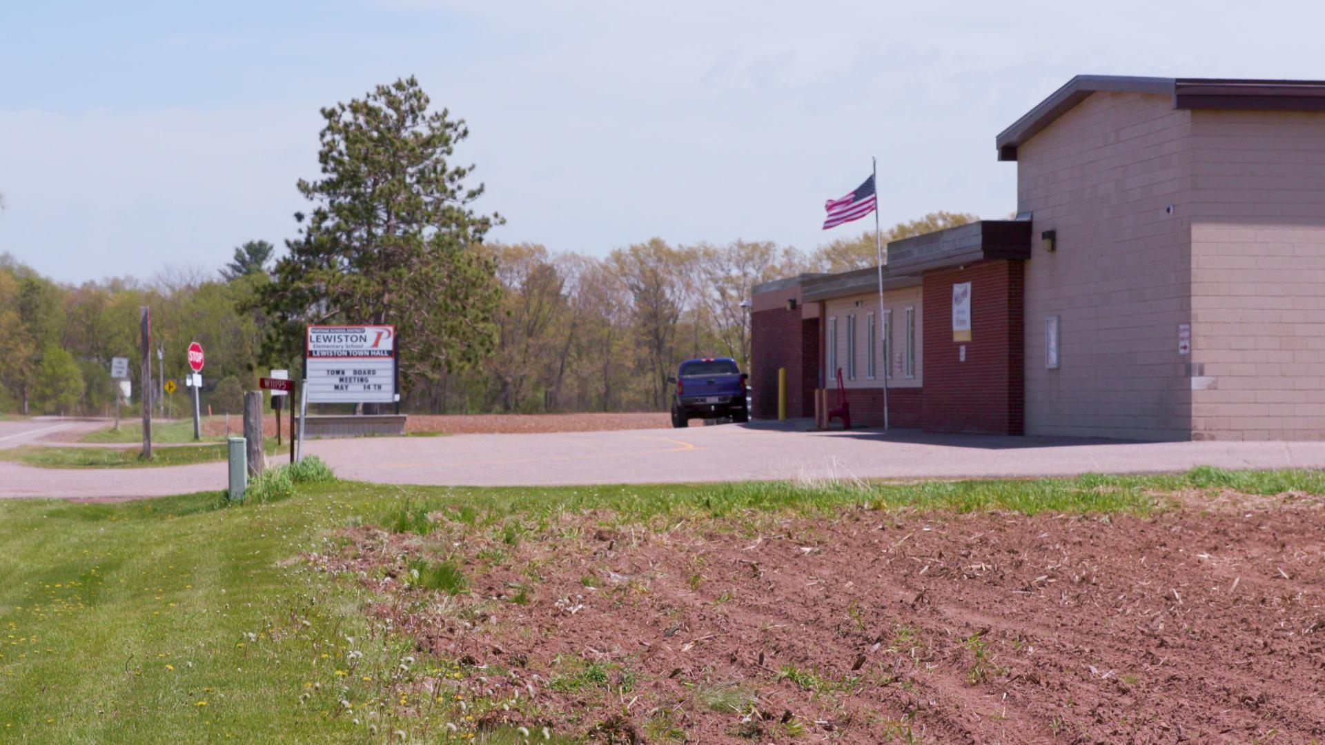 A still image shows a line of school busses picking up students as they depart from school. A still image shows a line of school busses picking up students as they depart from school.
