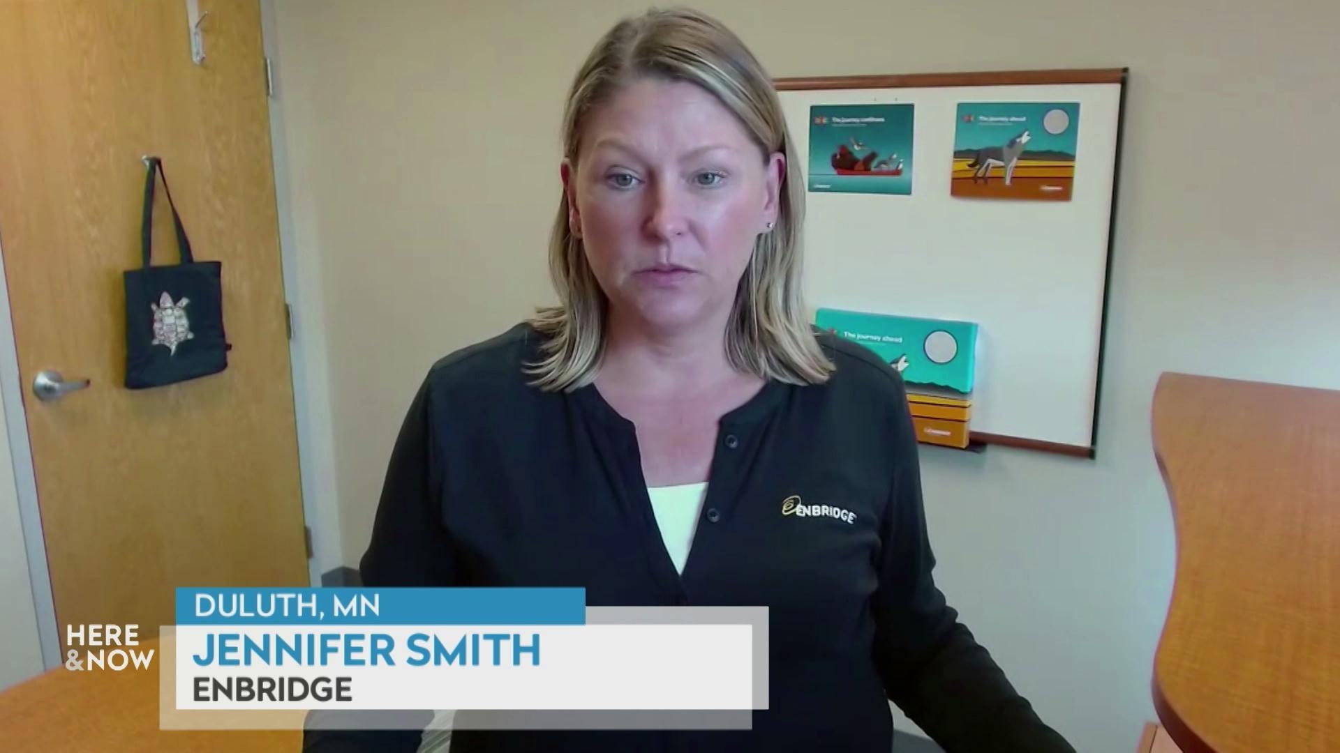 A still image shows Jennifer Smith at a desk in front of a white board, with a graphic at the bottom that reads 'Duluth, MN,' 'Jennifer Smith' and 'Enbridge.'