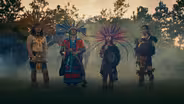 Dulé Learns the Mexica Handshake from Aztec Dancer Rainflowa