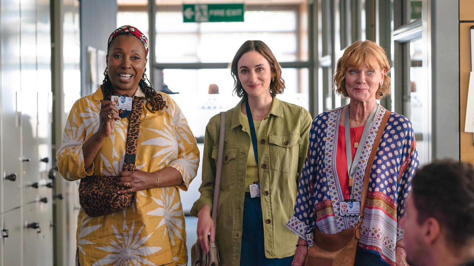 The three women, smiling.