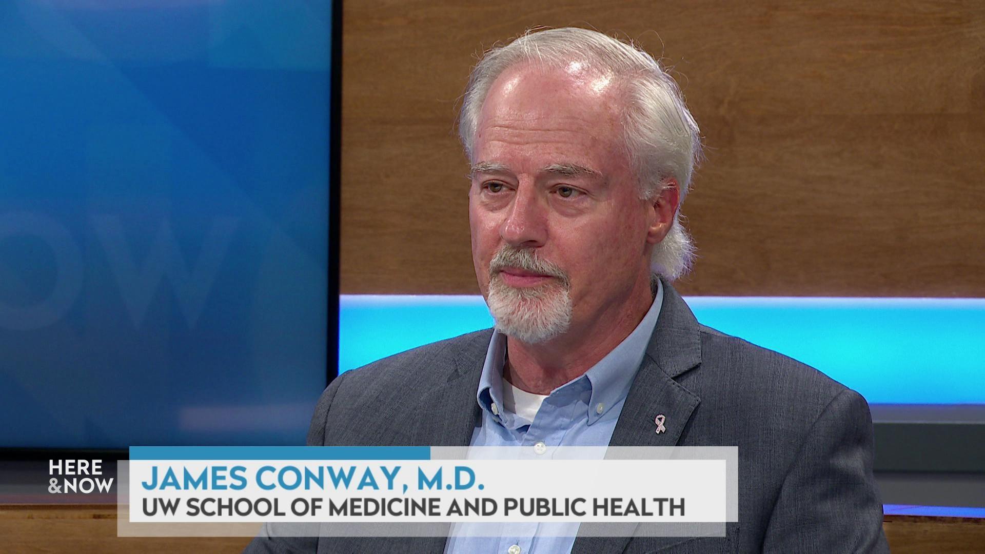 A still image shows Dr. James Conway seated at the 'Here & Now' set featuring wood paneling, with a graphic at bottom reading 'James Conway, M.D.' and 'UW School of Medicine and Public Health.'