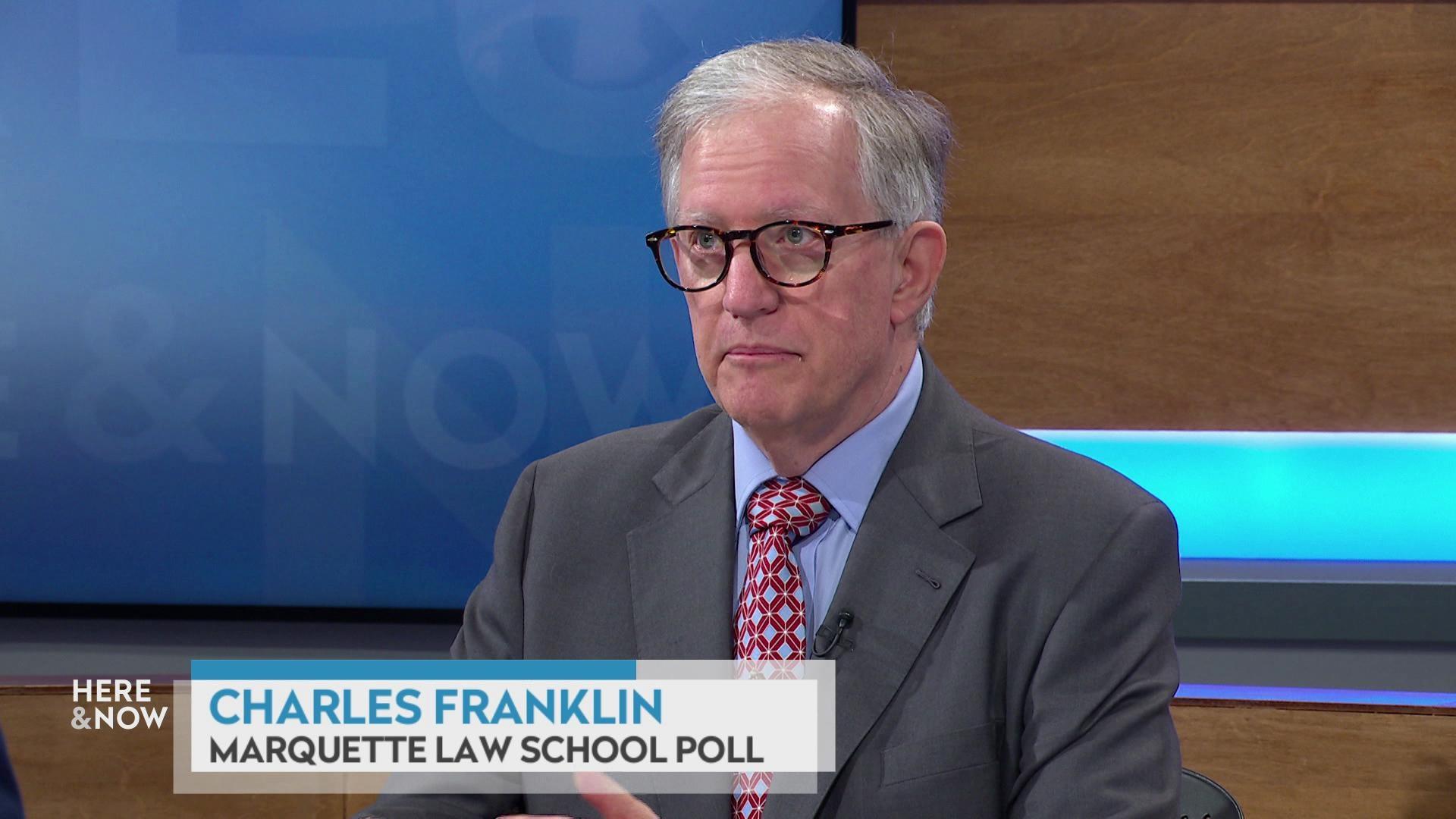 A still image shows Charles Franklin seated at the 'Here & Now' set featuring wood paneling, with a graphic at bottom reading 'Charles Franklin' and 'Marquette Law School Poll.'