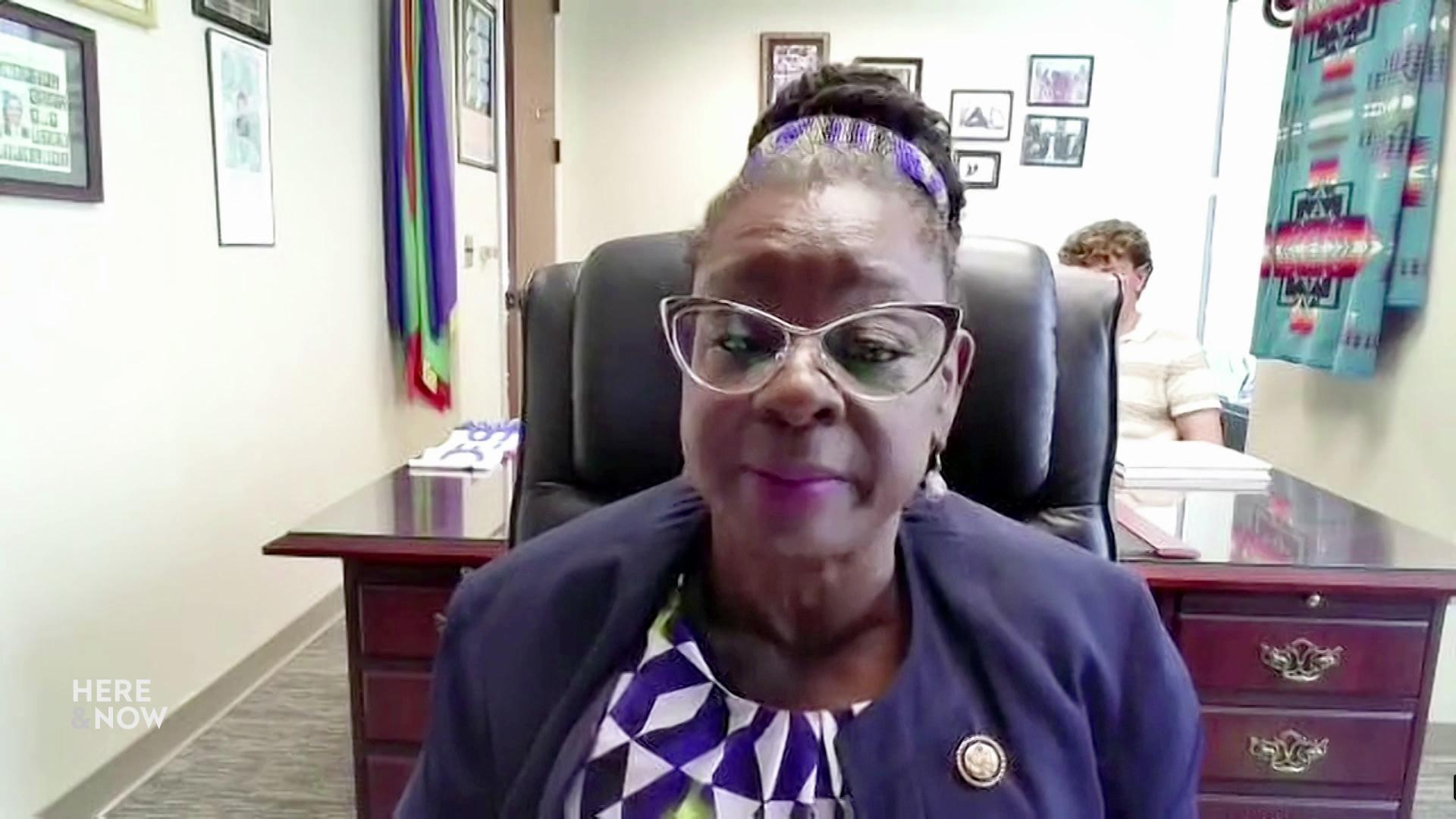 A still image shows U.S. Representative Gwen Moore seated in front of an ornate wood desk with a graphic at the bottom that reads 'U.S. Rep. Gwen Moore' and '(D) Fourth Congressional District.'