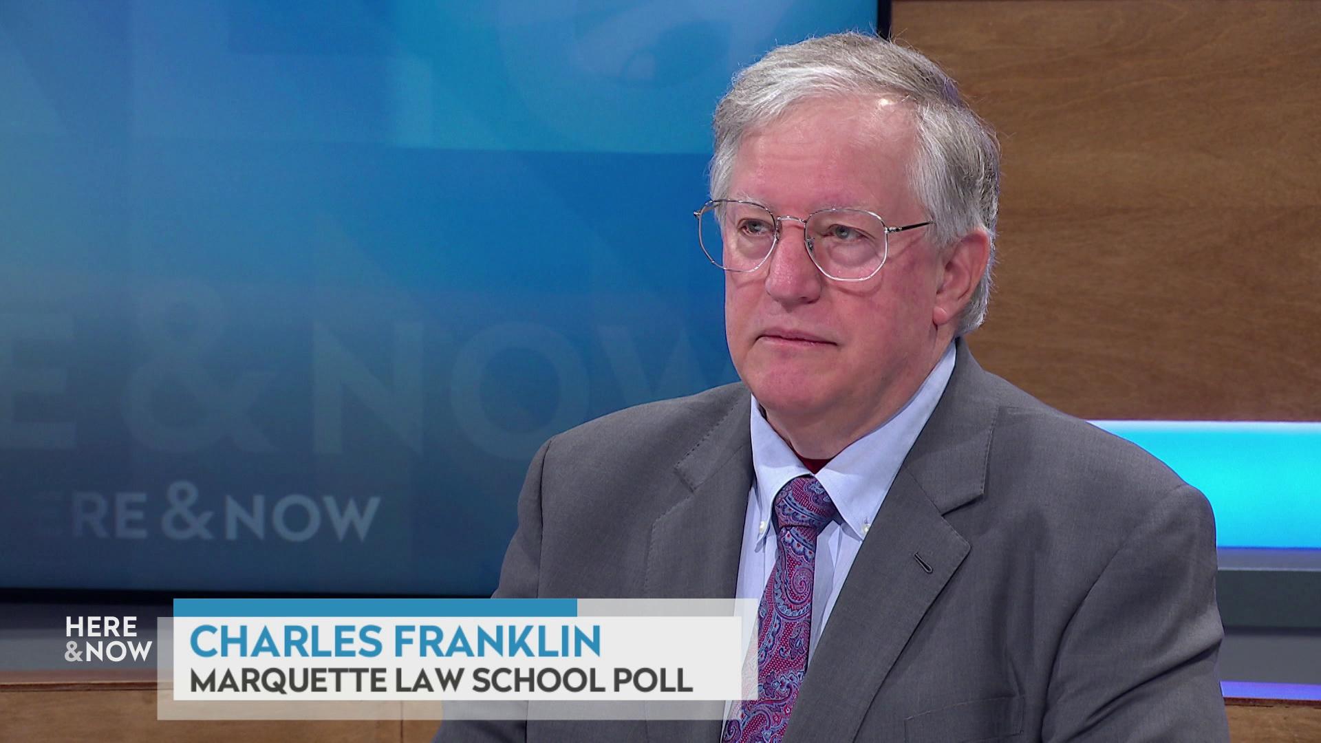 A still image shows Charles Franklin seated at the 'Here & Now' set featuring wood paneling, with a graphic at bottom reading 'Charles Franklin' and 'Marquette Law School Poll.'