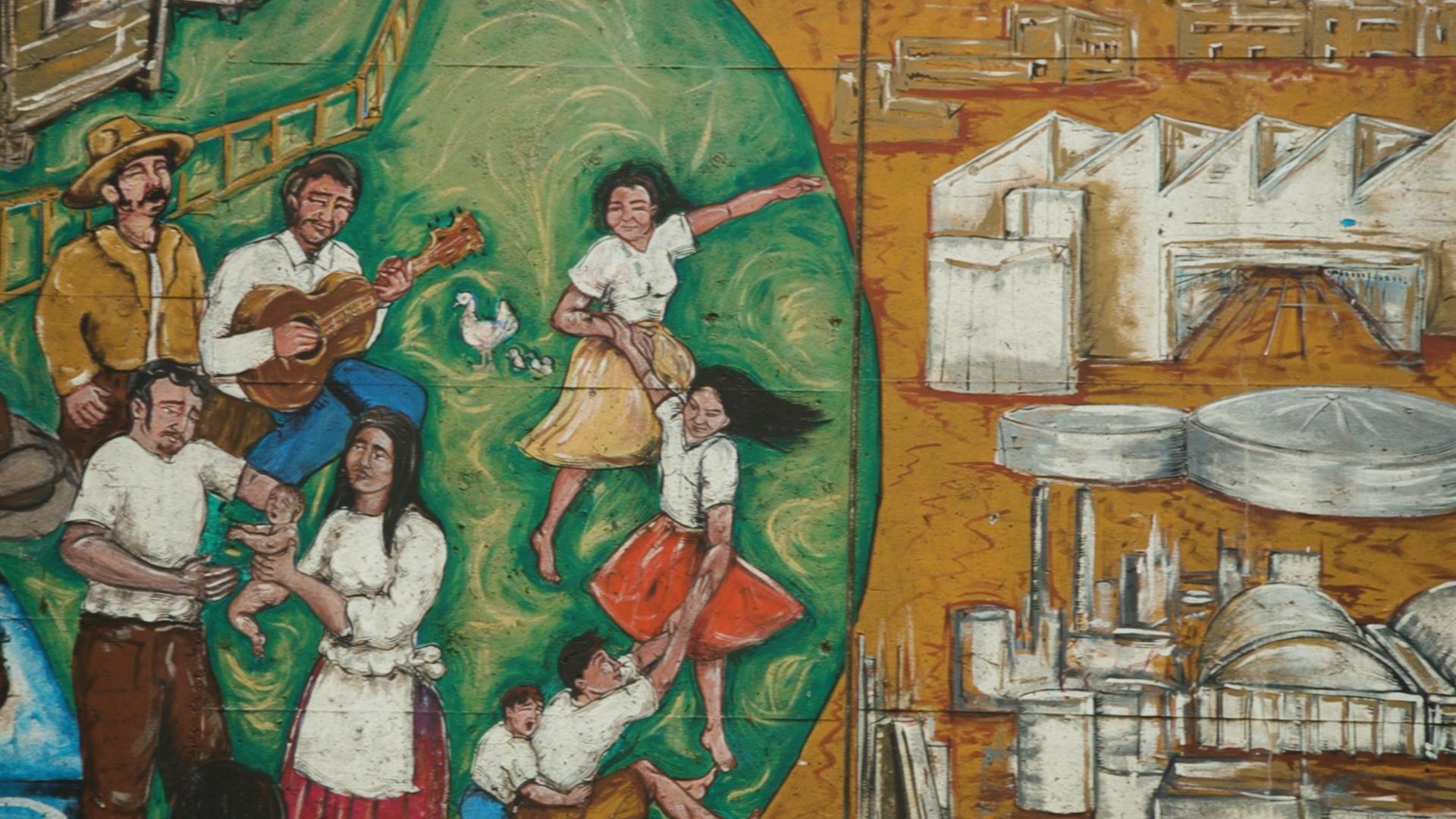 A section of mural depicting families next to an industrial area