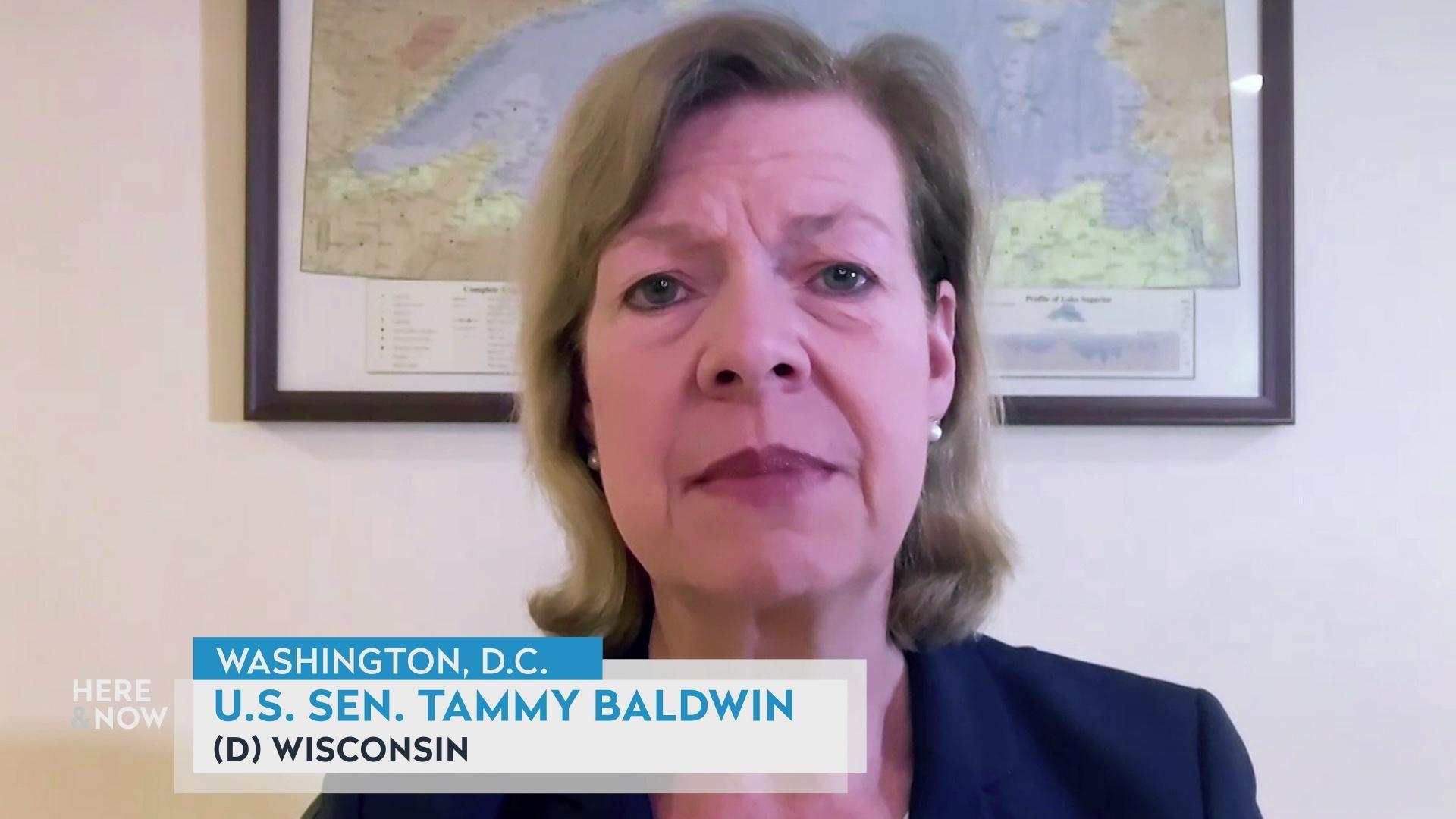 A still image from a video shows Tammy Baldwin sitting with a map of Lake Superior in the background, with a graphic at bottom reading 'U.S. Sen. Tammy Baldwin' and '(D) Wisconsin.'