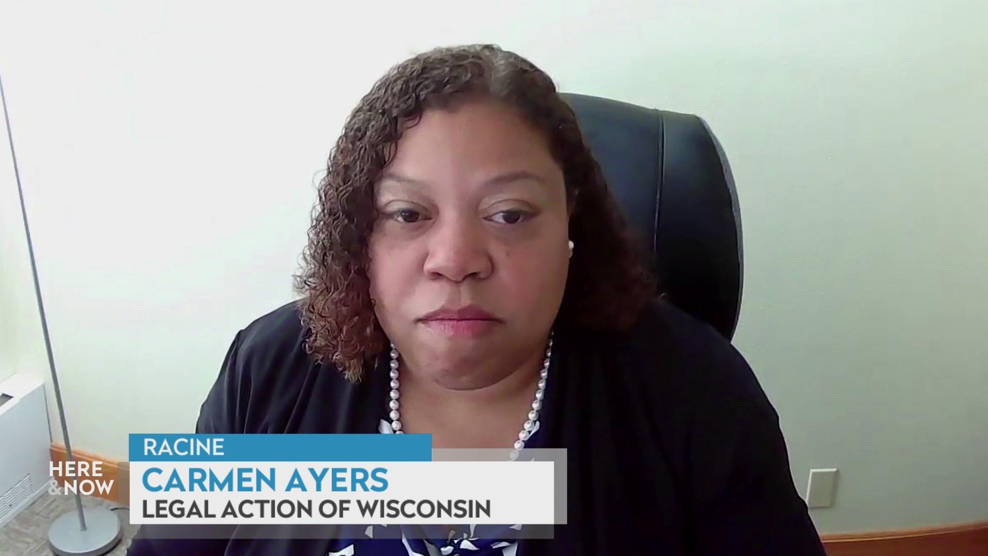A still image from a video shows Carmen Ayers seated in a high-back black chair in front of a blank wall with a graphic at bottom reading 'Racine,' 'Carmen Ayers' and 'Legal Action of Wisconsin.'