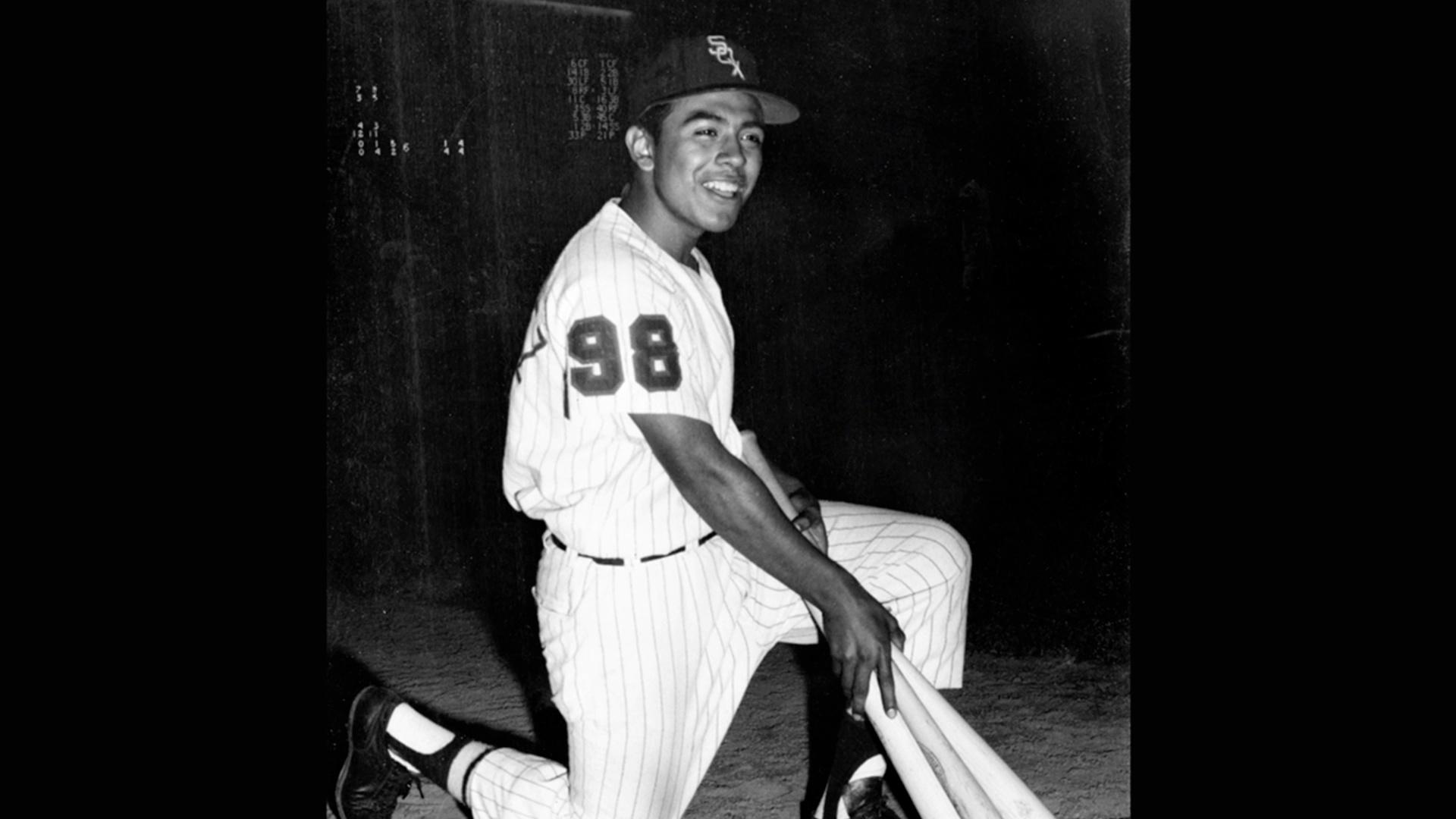 Eddy Cervantez kneeling in baseball uniform with bat in hand