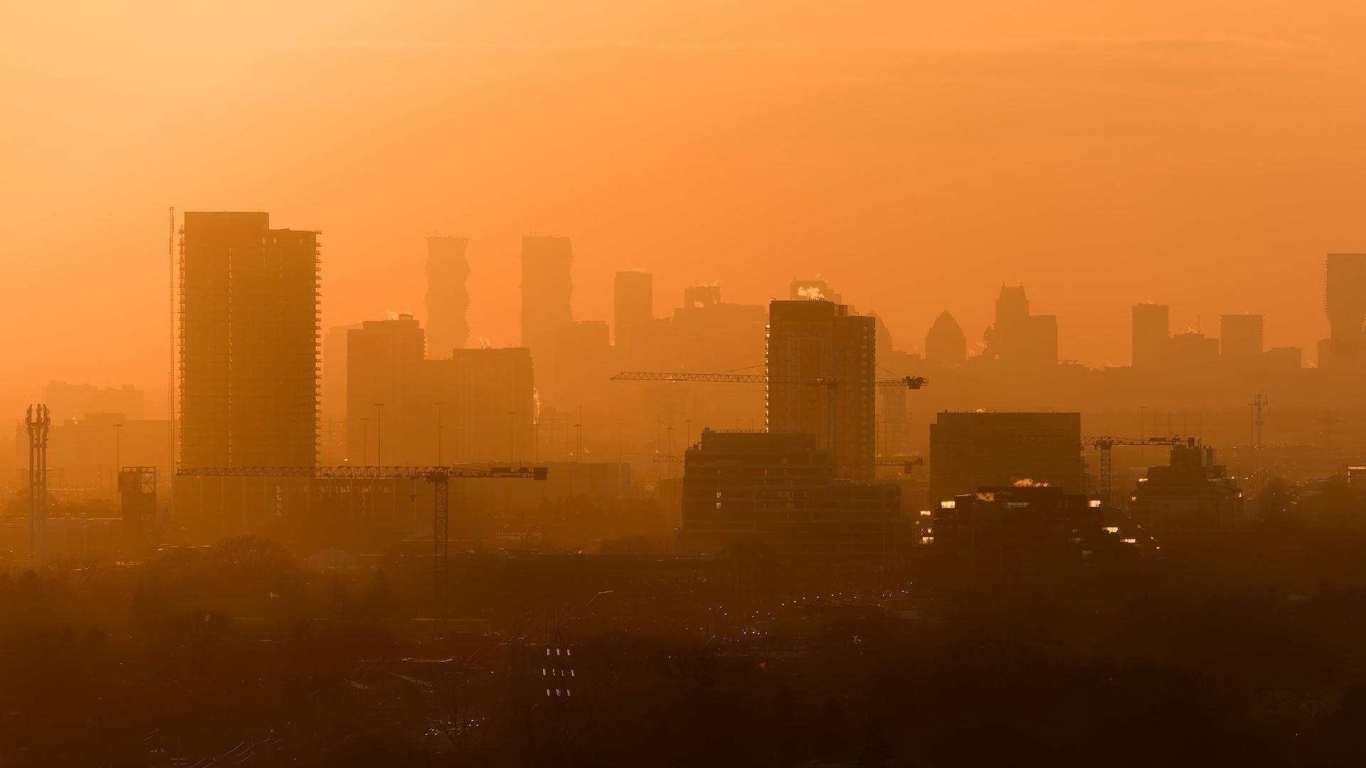 A city skyline with orange haze. 