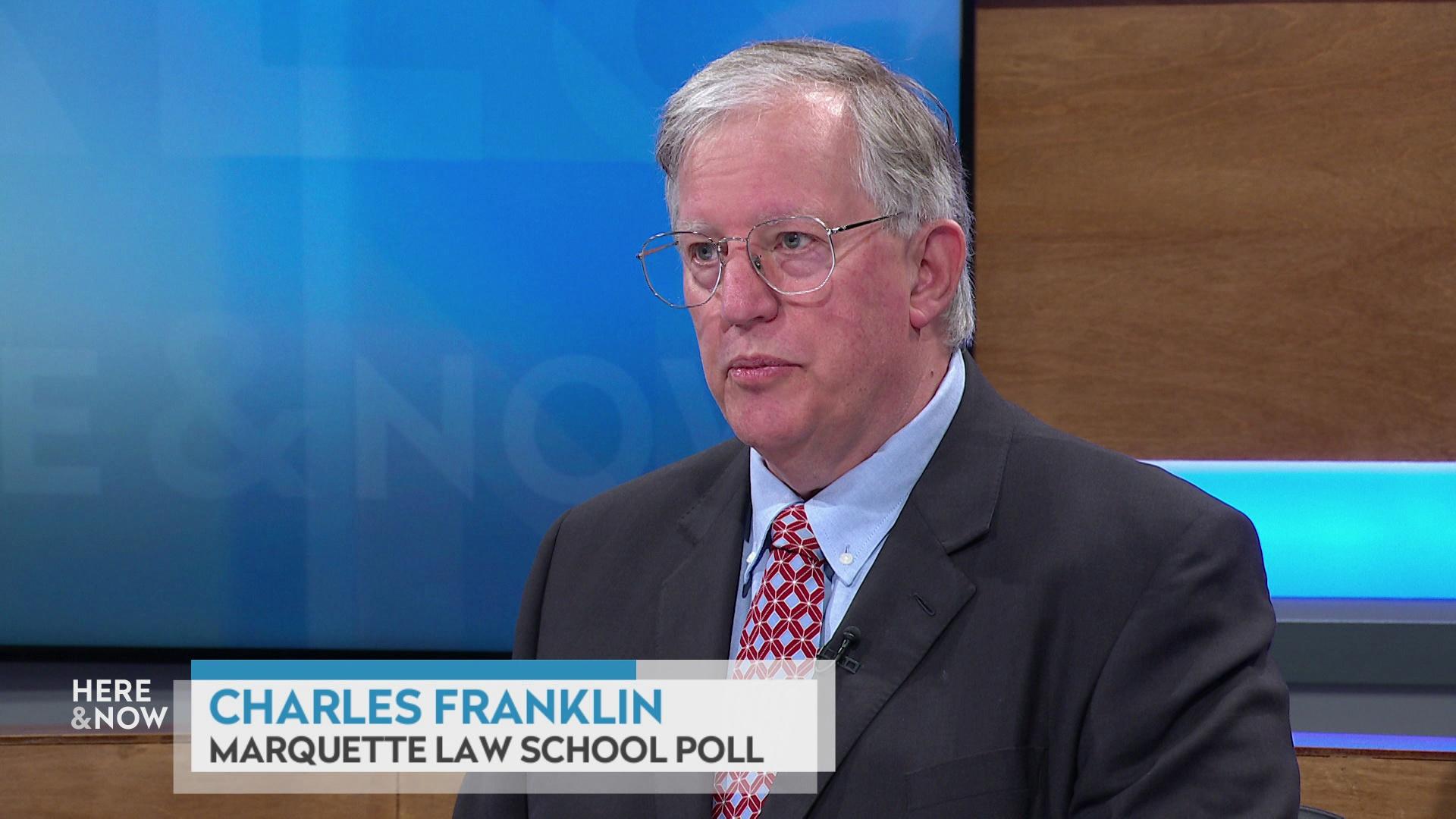 A still image shows Charles Franklin seated at the 'Here & Now' set featuring wood paneling, with a graphic at bottom reading 'Charles Franklin' and 'Marquette Law School Poll.'