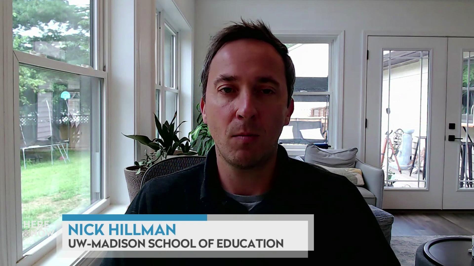 A still image shows Nick Hillman seated in a room with many windows and a couch, with a graphic at the bottom that reads 'Nick Hillman' and 'UW-Madison School of Education.'