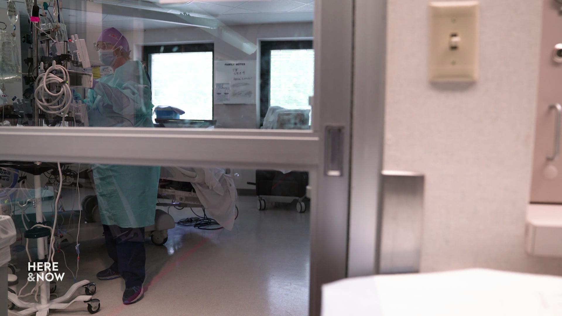 A still image shows a doctor in full scrubs operating medical machinery behind a glass door.