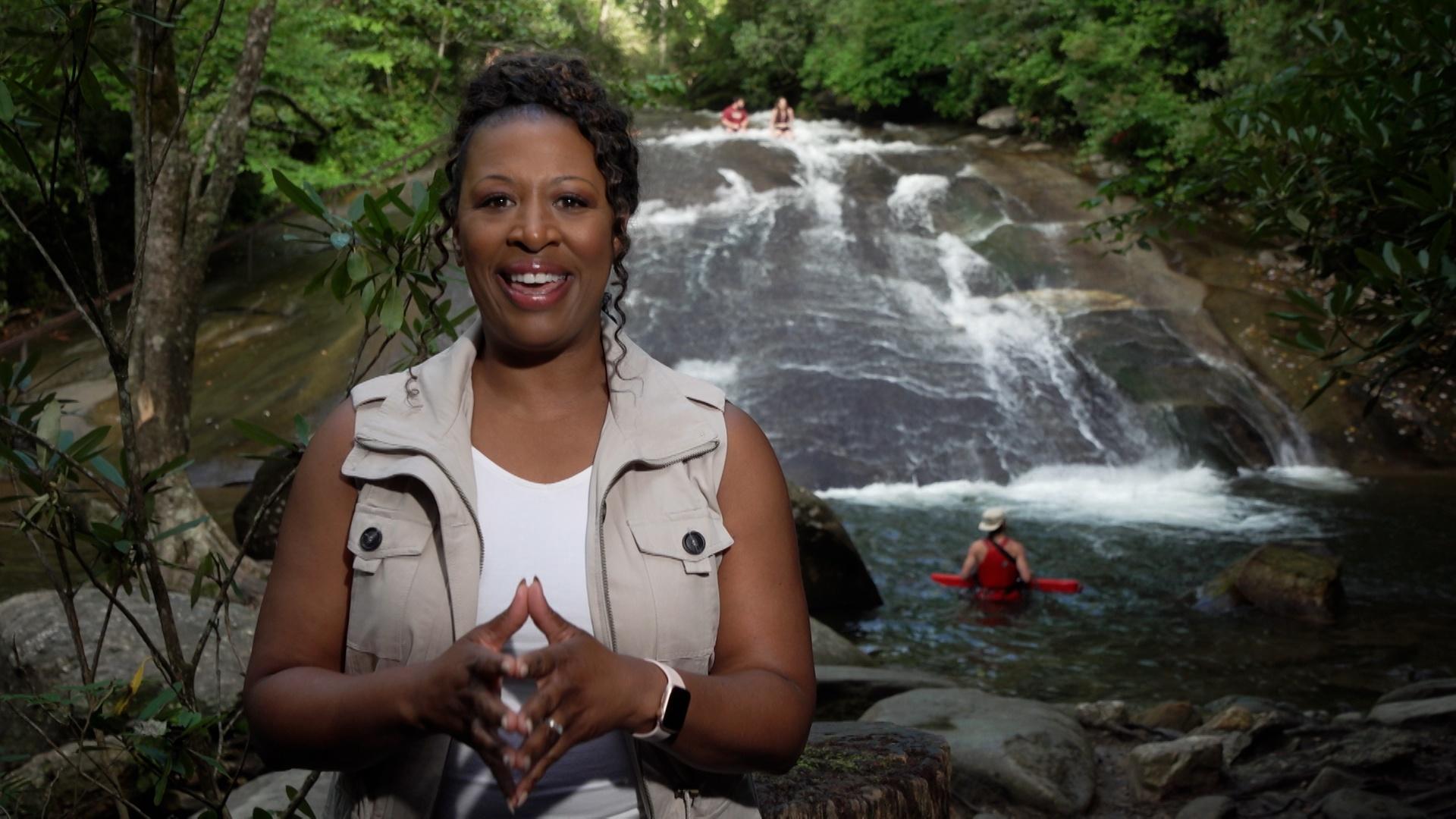 Host Deborah Holt Noel in front of a waterfall in Brevard, NC.