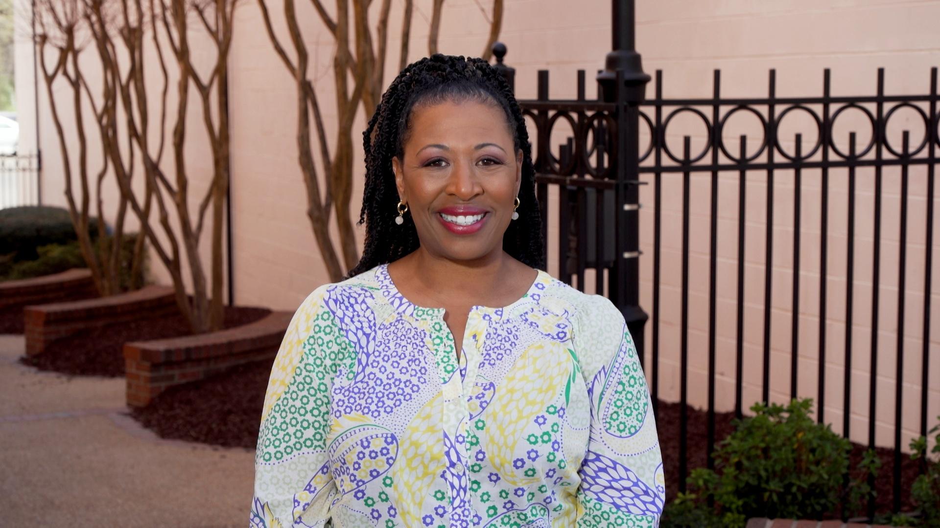 Deborah Holt Noel in front of a gate and alley.