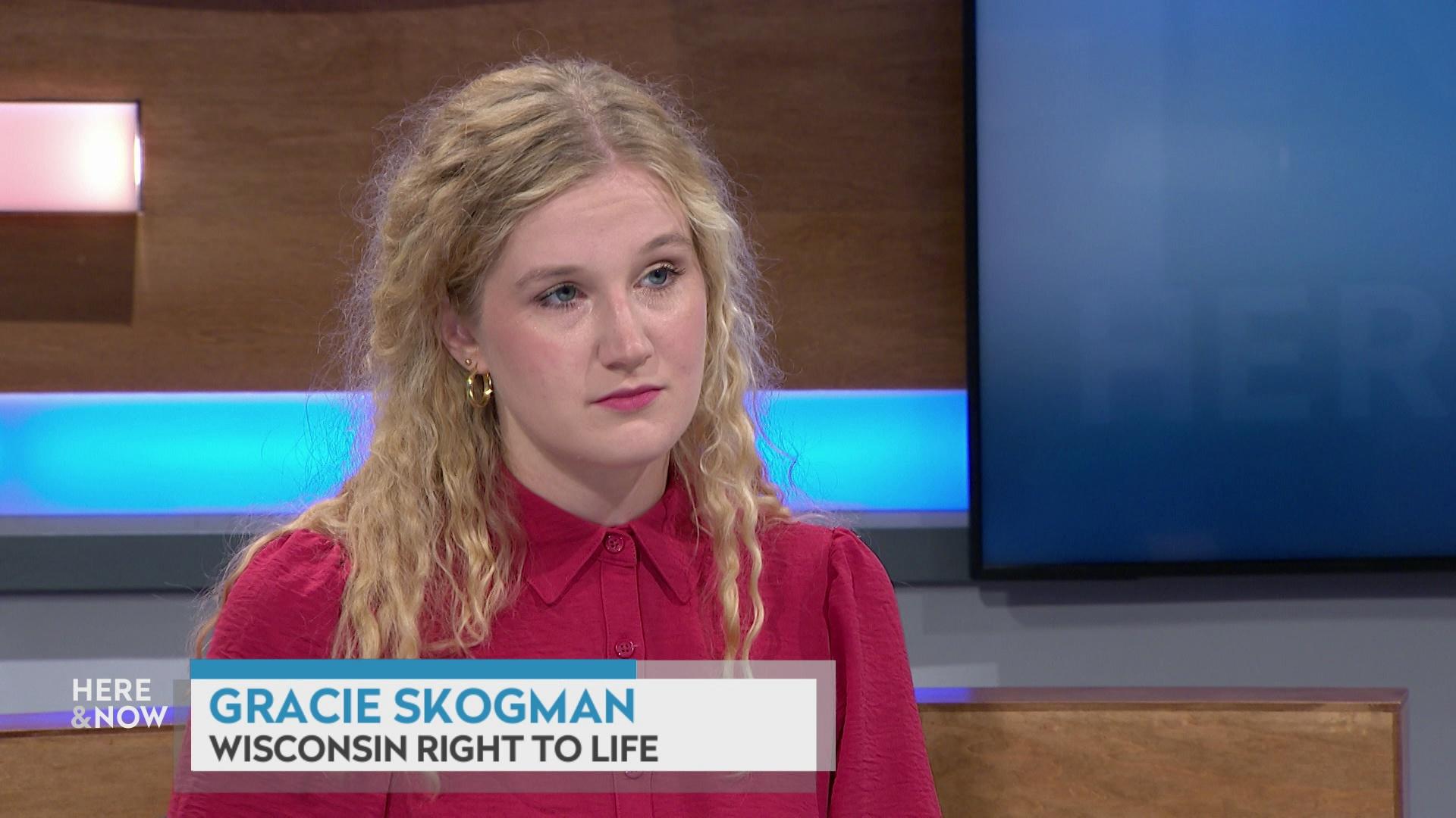 A still image shows Gracie Skogman seated at the 'Here & Now' set featuring wood paneling, with a graphic at bottom reading 'Gracie Skogman' and 'Wisconsin Right to Life.'
