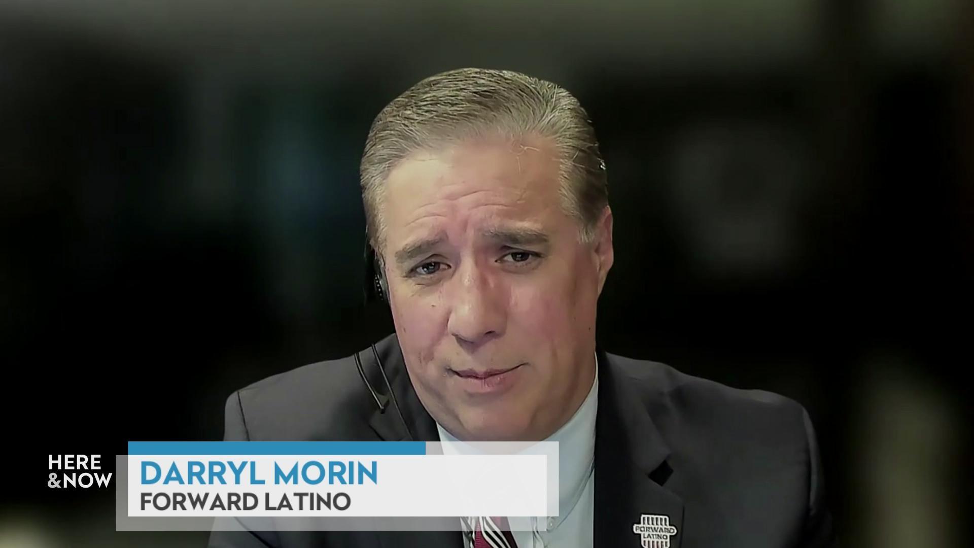 A still image from a video shows Darryl Morin seated in front of a blurred background with a graphic at the bottom reading 'Darryl Morin' and 'Forward Latino.'