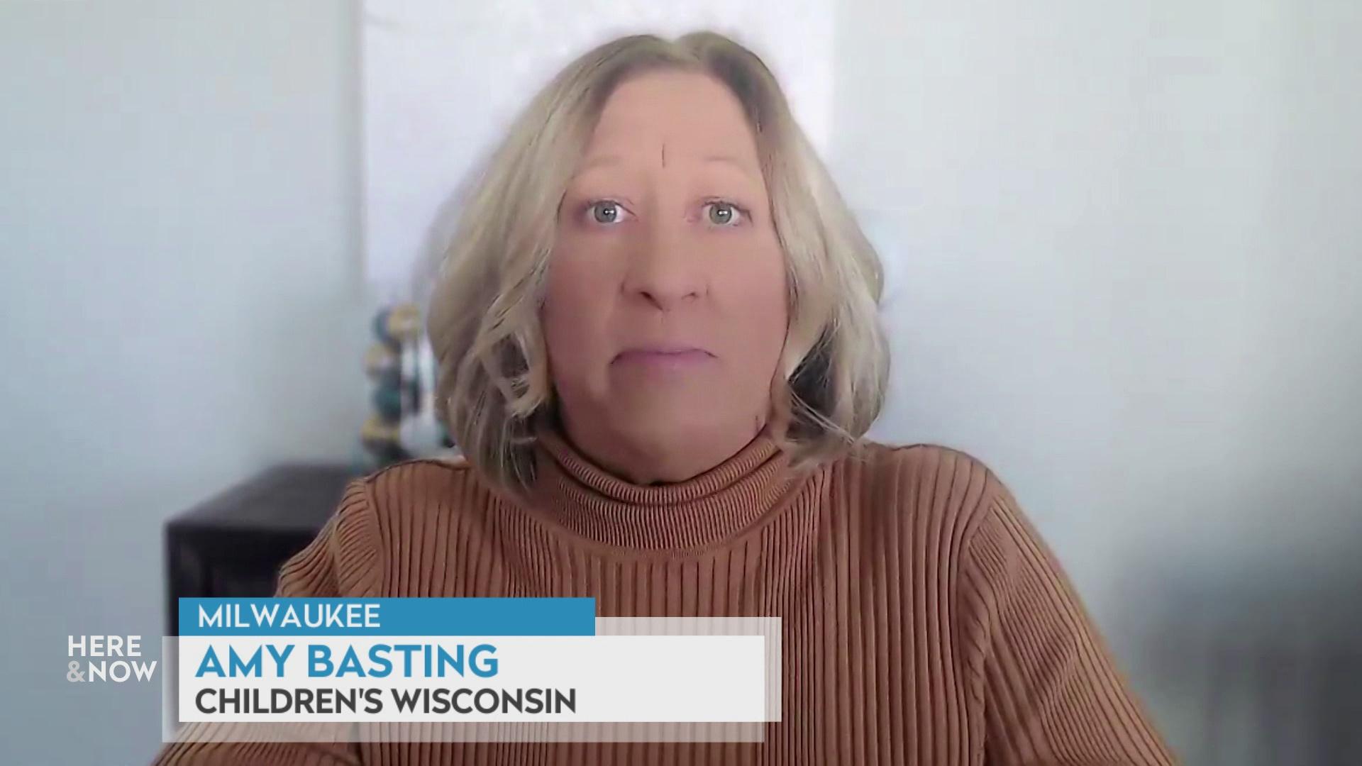 A still image from a video shows Amy Basting seated in front of a blurred background with a graphic at bottom reading 'Milwaukee,' 'Amy Basting' and 'Children's Wisconsin.'