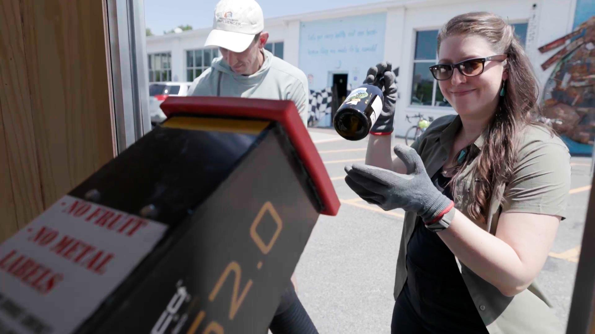 Sci NC producer Michelle Lotker throwing a glass wine bottle into a recycling center.