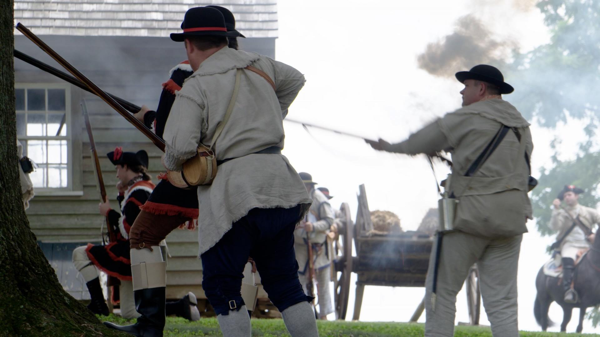 Revolutionary War reenactors in the middle of reenacting a battle.