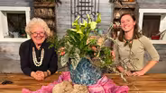 A floral arrangement, gardening tools, and flowering vines