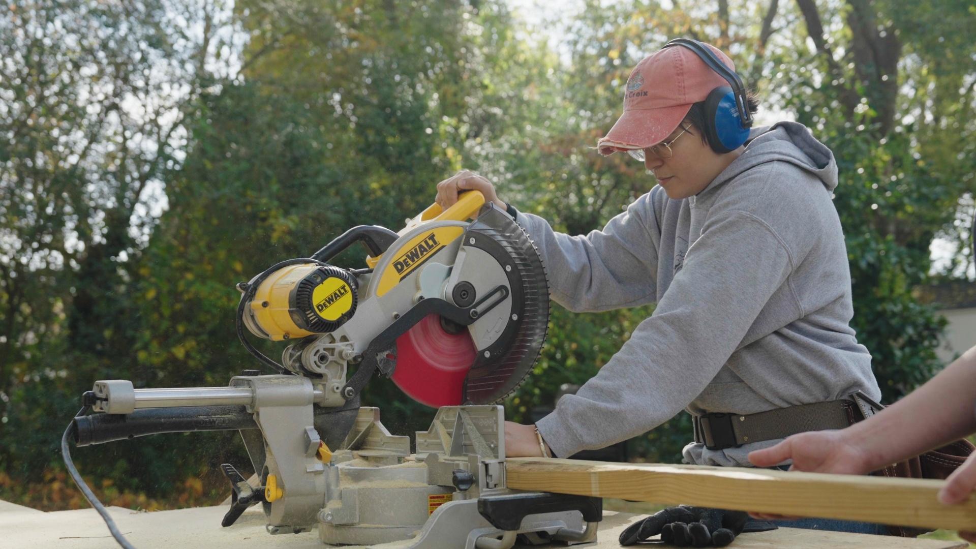 A person cutting wood with a circular power saw.