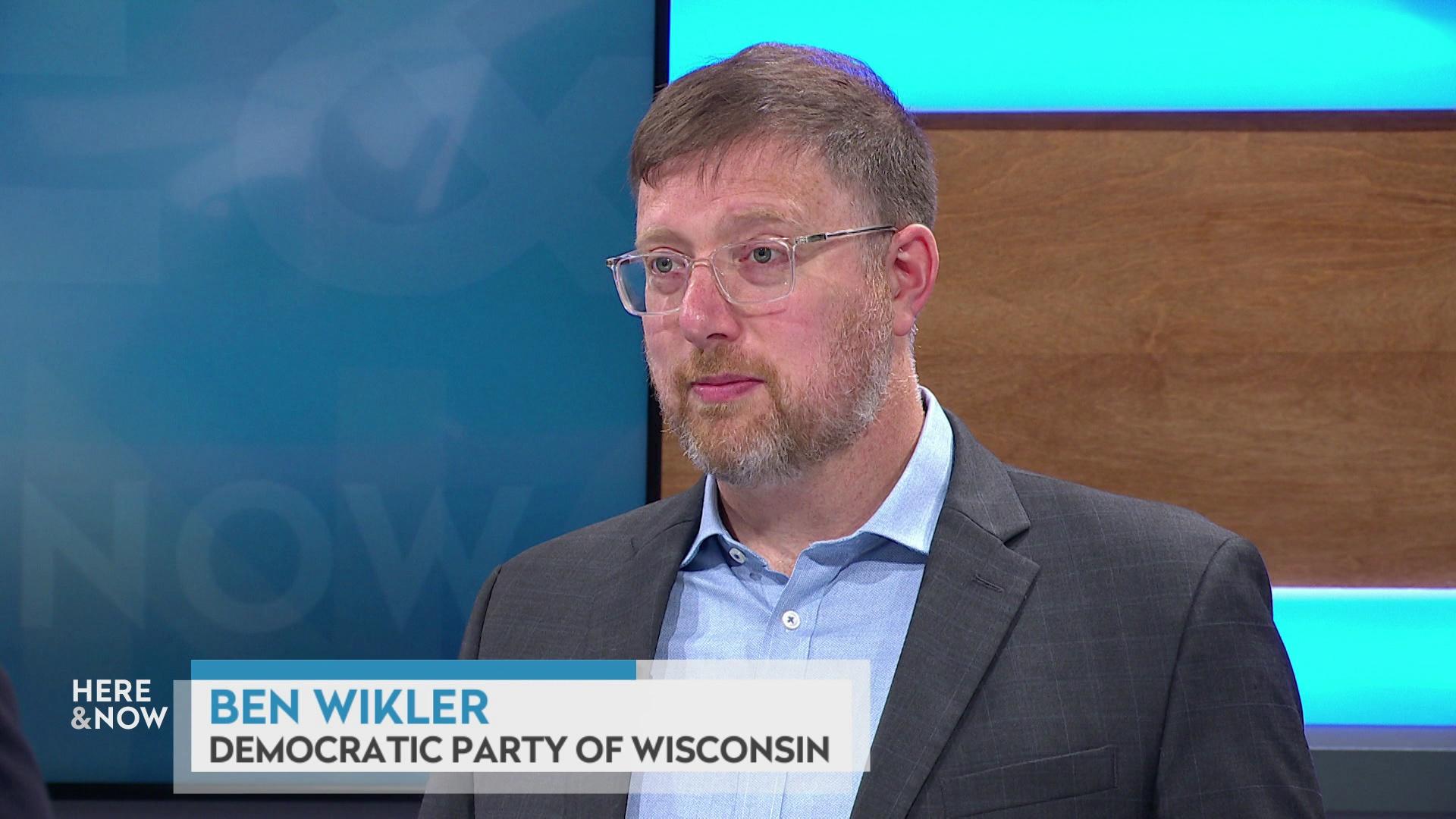 A still image shows Ben Wikler seated at the 'Here & Now' set featuring wood paneling, with a graphic at bottom reading 'Ben Wikler' and 'Democratic Party of Wisconsin.'