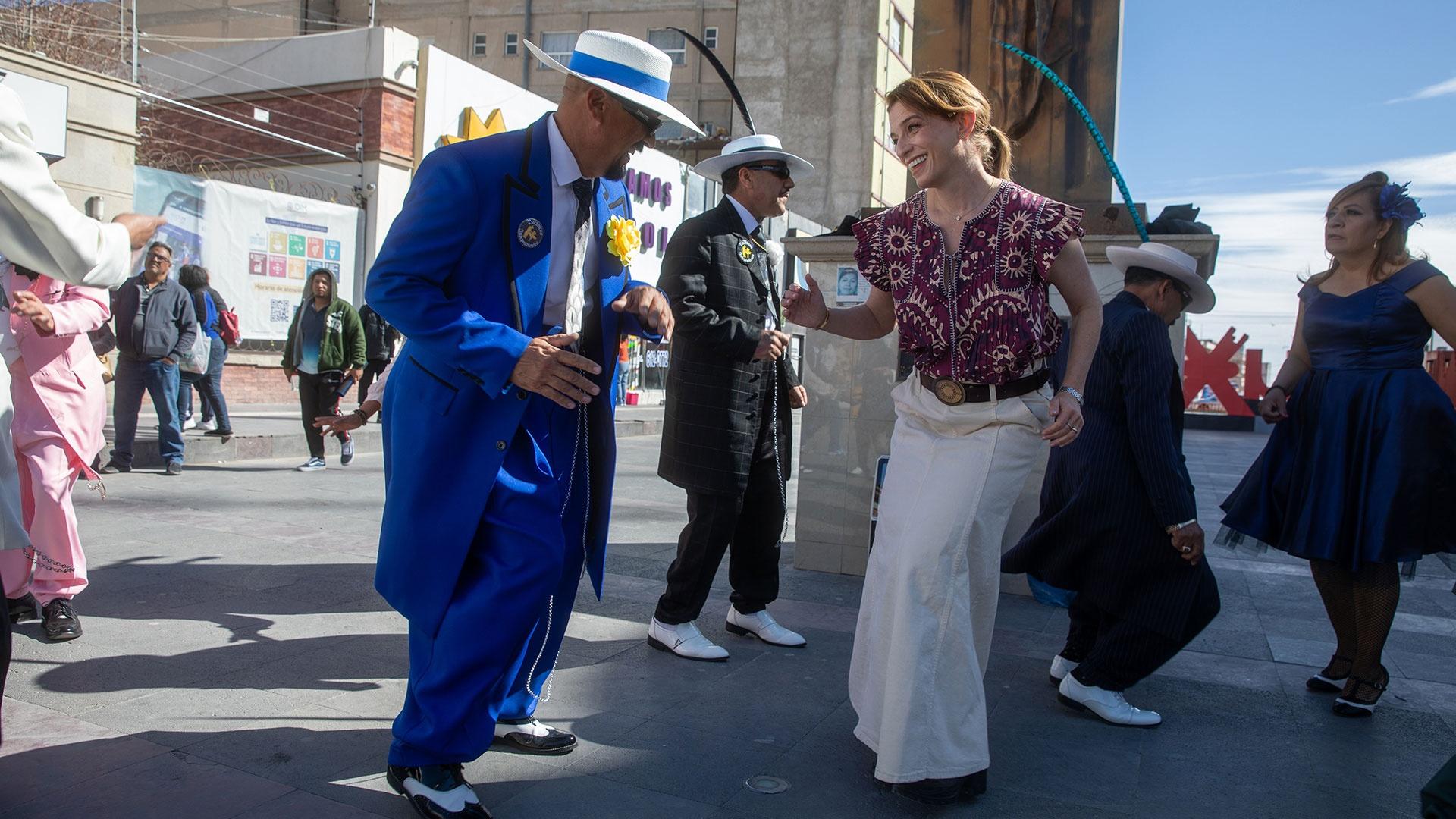 Pati Jinich dances with a man in a bright blue suit.