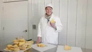 Inga Slices a Truckle of Wisconsin Cheese