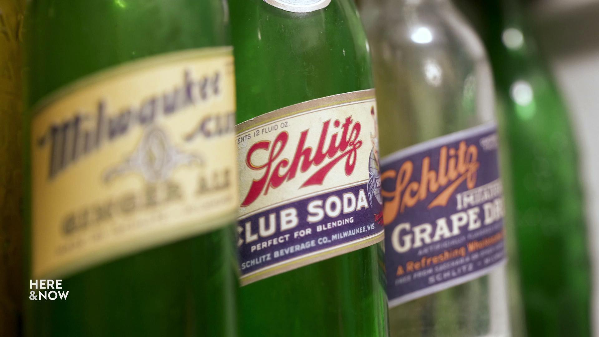 A still image shows four historic bottles of Schlitz lined up in a row.