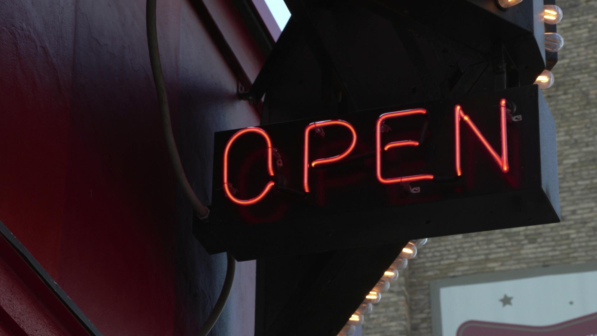 A neon open sign is lit up outside a local restaurant.