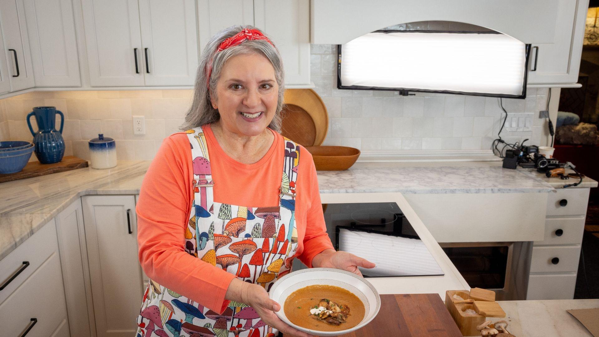 Sheri Castle holding a bowl of double mushroom soup.