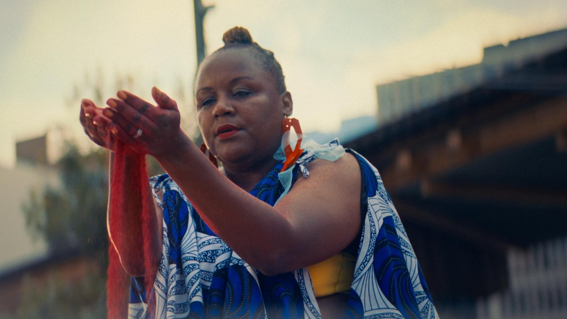 Vershawn Sanders Ward examines red sand as she thinks back to her West African dance roots.