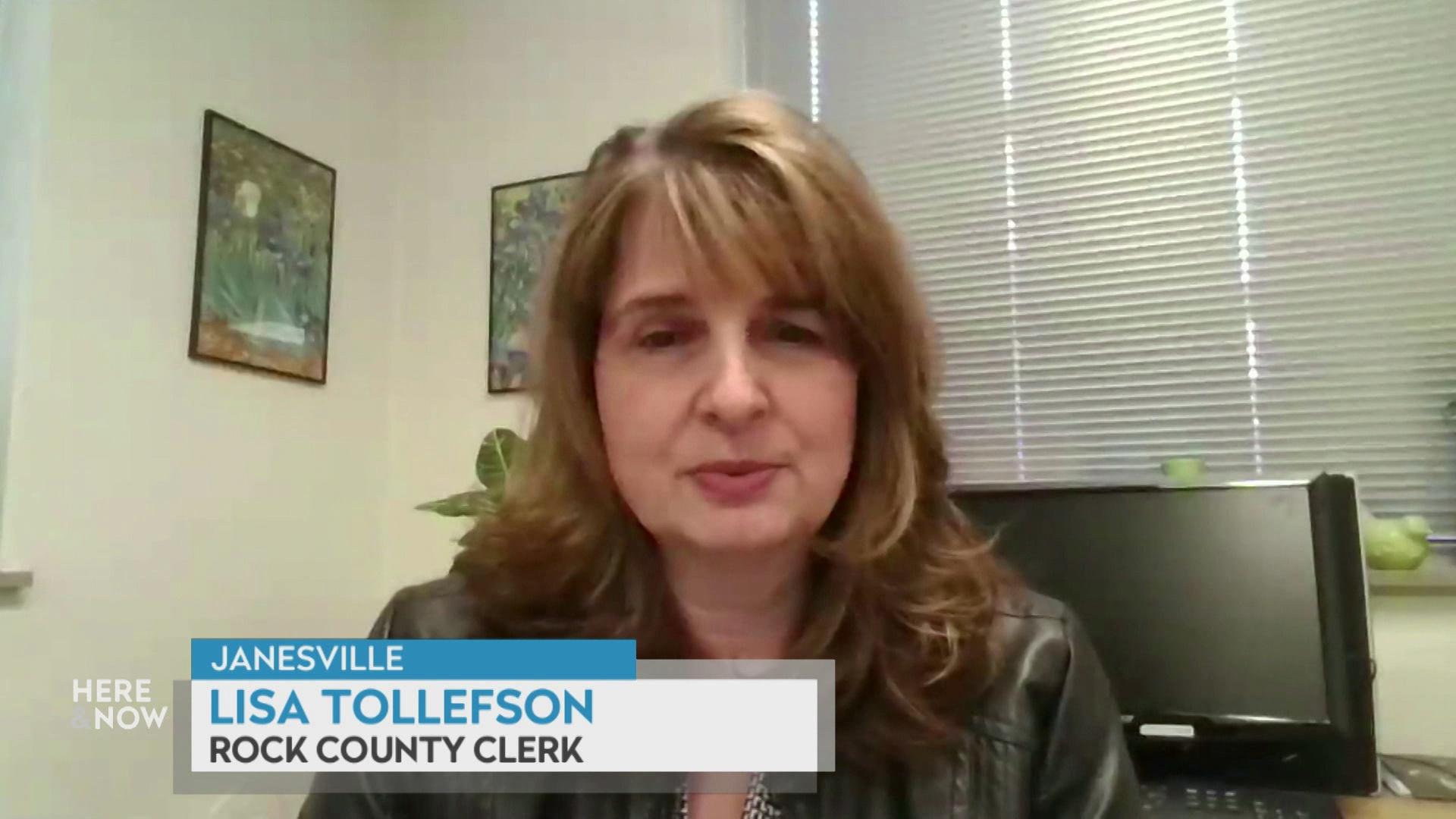 A still image from a video shows Lisa Tollefson seated in front of a window with blinds and framed poster with a graphic at bottom reading 'Janesville,' 'Lisa Tollefson' and 'Rock County Clerk.'