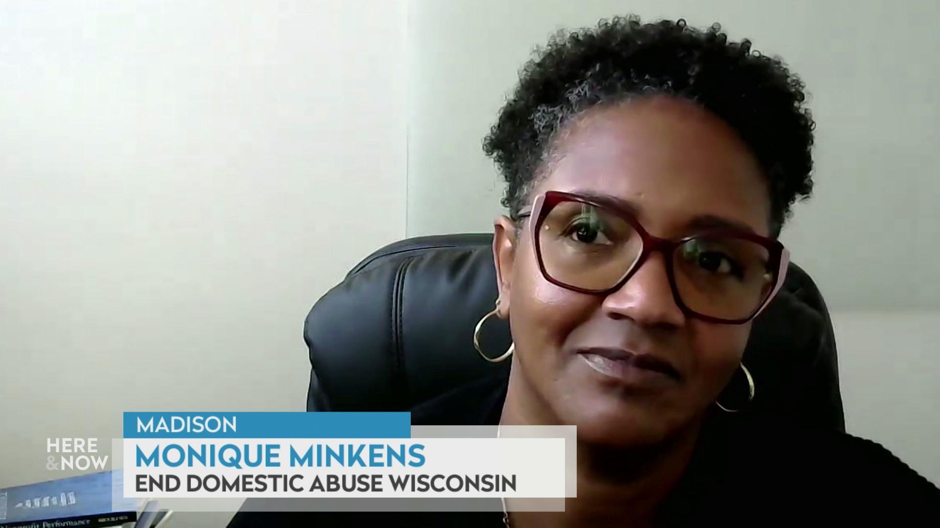 A still image shows Monique Minkens seated in front of a plain white wall, with a graphic at the bottom that reads 'Madison,' 'Monique Minkens' and 'End Domestic Abuse Wisconsin.'