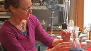 Ceramic artist Susan Garson paints a menorah