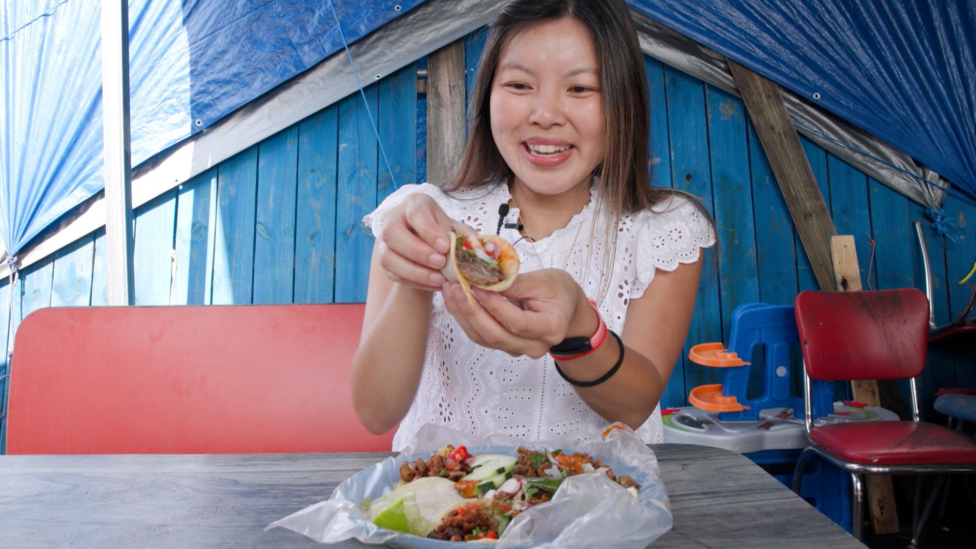Linda Nguyen eating tacos at the Green Flea Market in Durham, NC.
