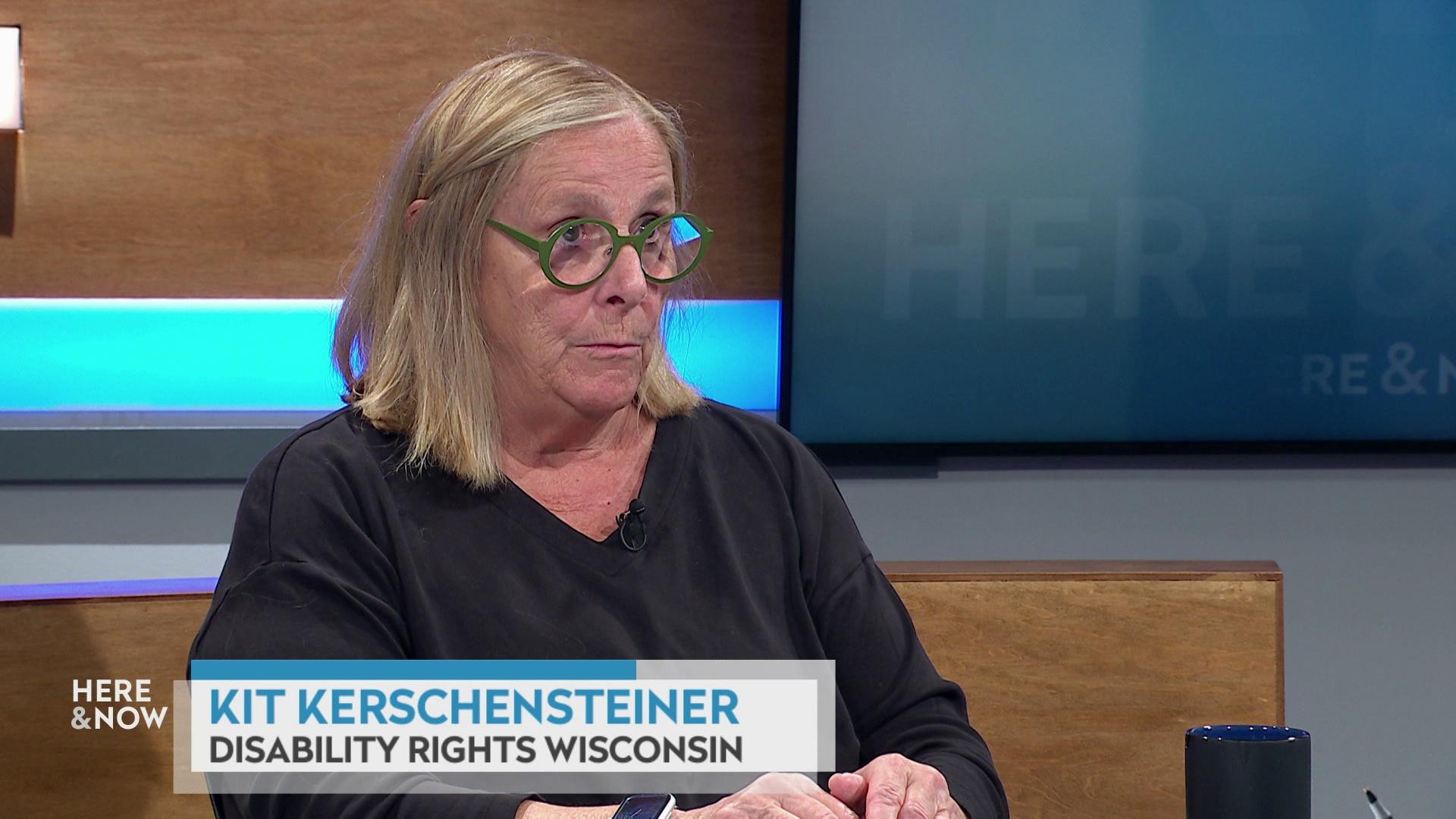 A still image shows Kit Kerchschensteiner seated at the 'Here & Now' set featuring wood paneling, with a graphic at bottom reading 'Kit Kerchschensteiner' and 'Disability Rights Wisconsin.'