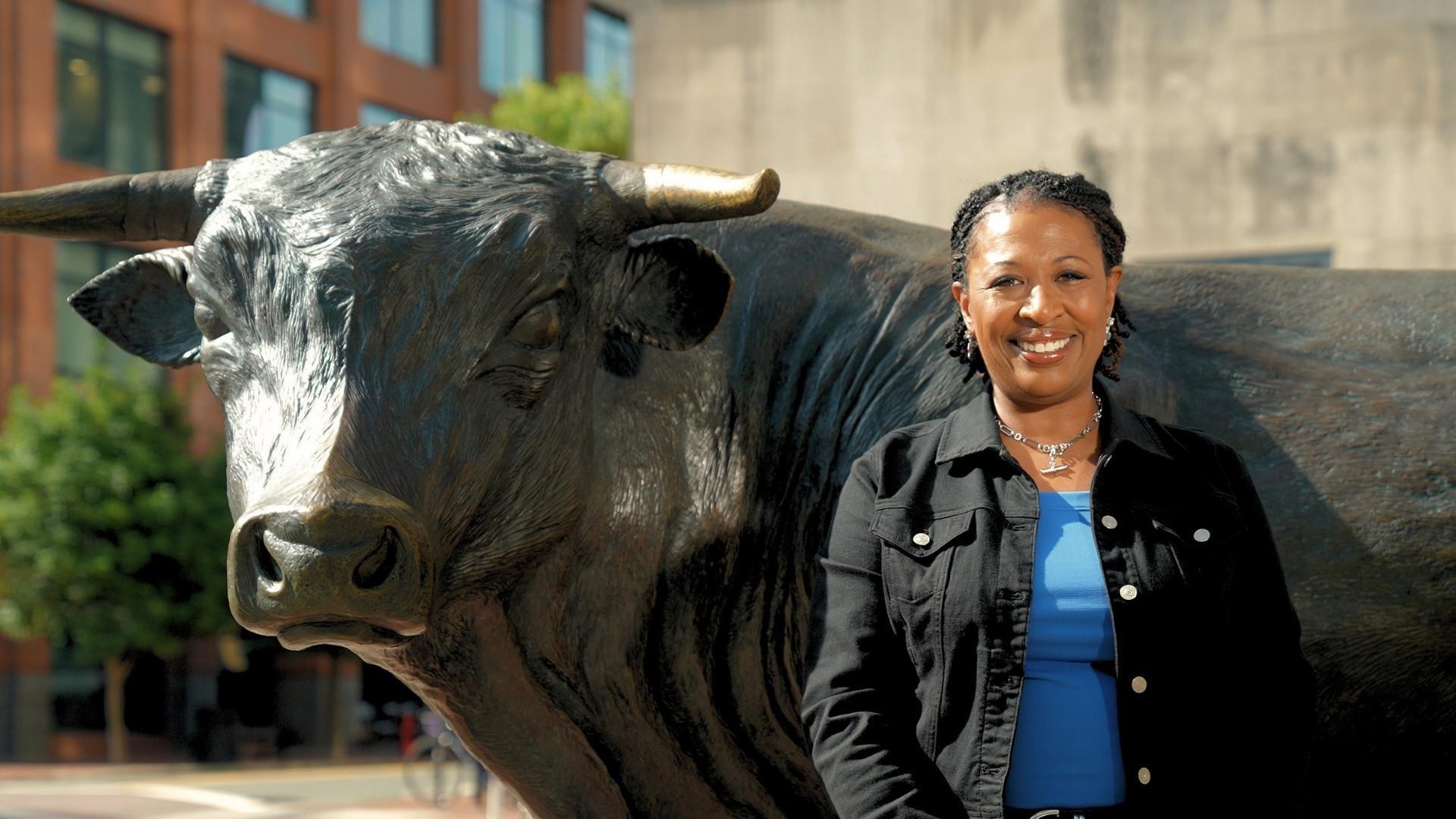 Host Deborah Holt Noel in front of the Bull statue in downtown Durham, NC.
